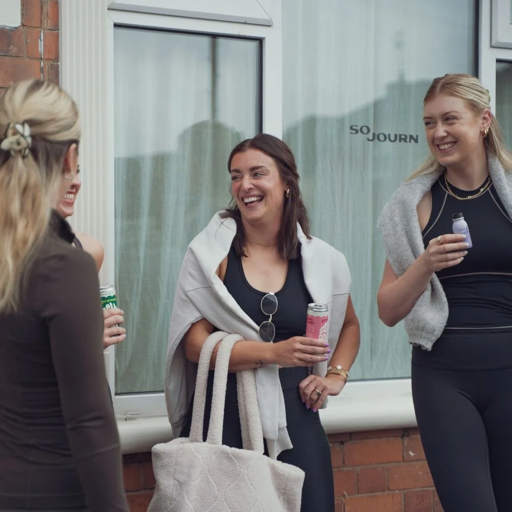Sojourn Pilates members chatting outside the studio in Broughton Astley after class, drinks in hand.