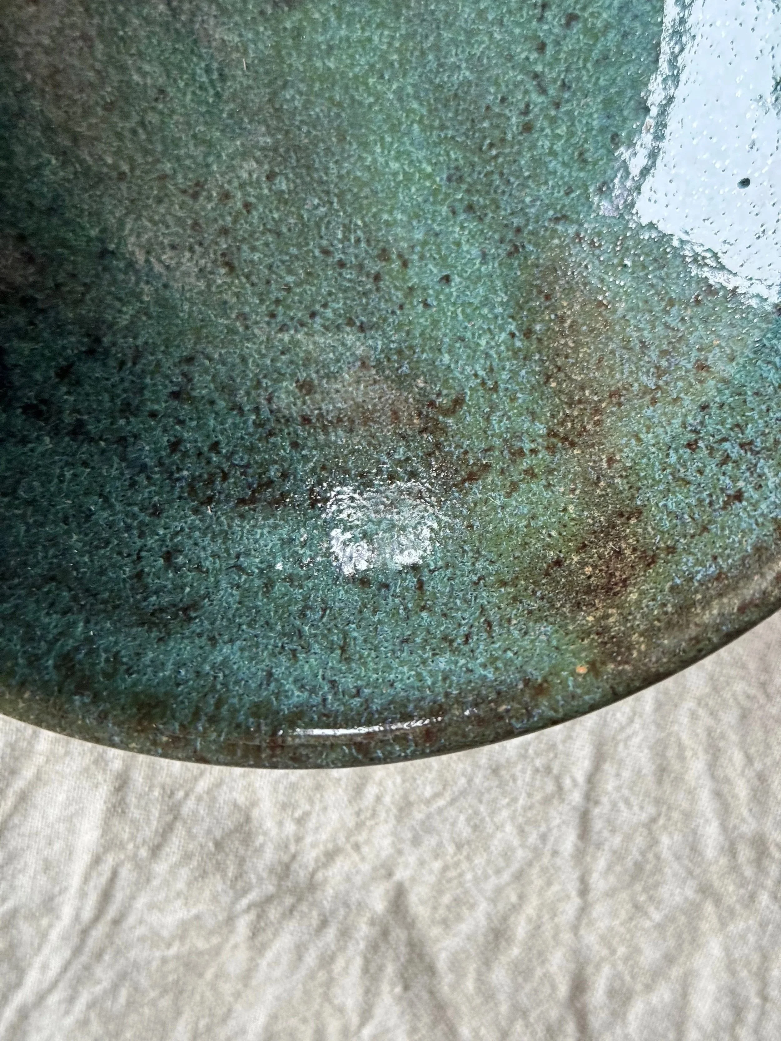 close up of green glaze on handmade ceramic bowl