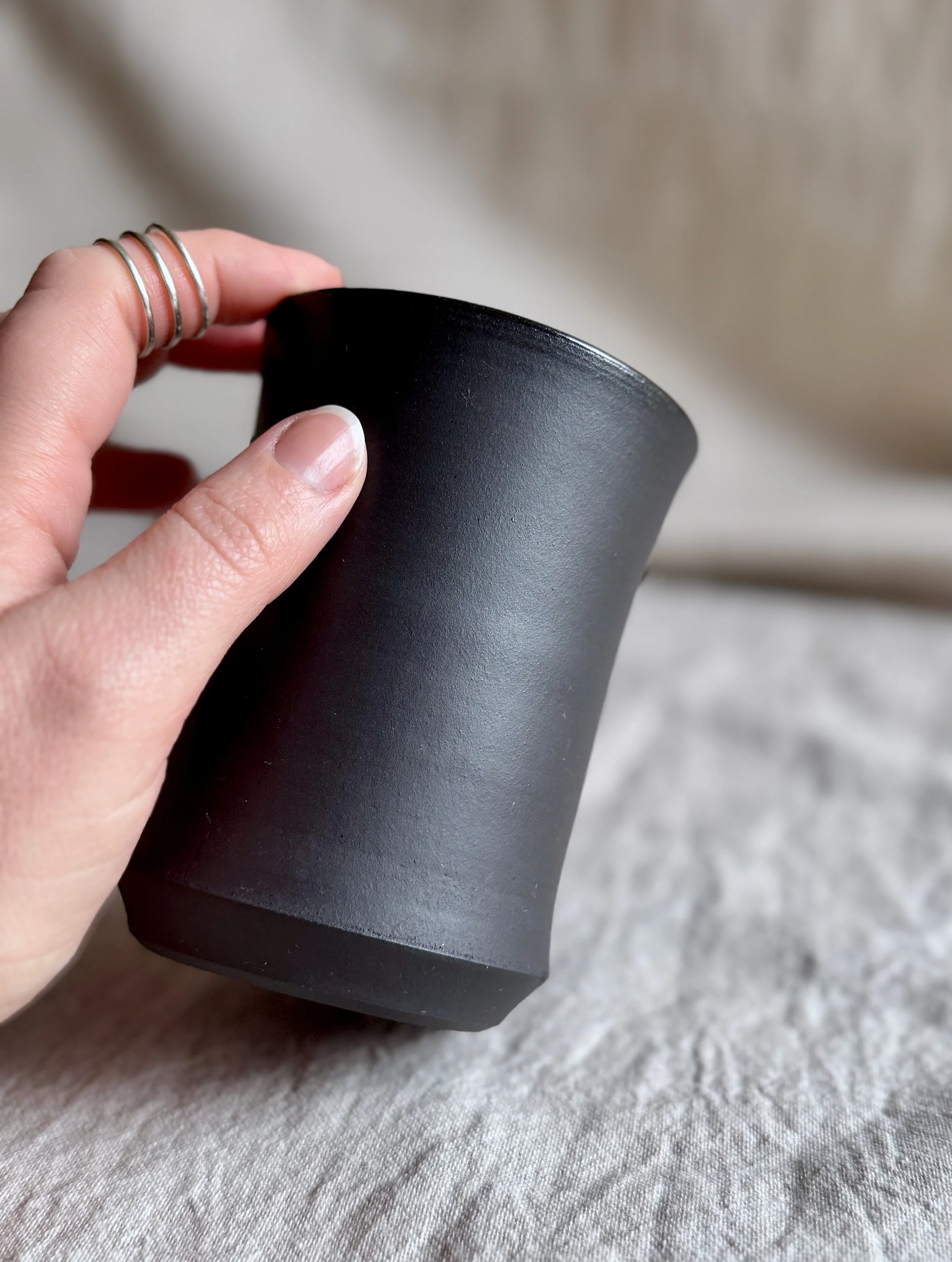 A handmade tumbler with matte black clay