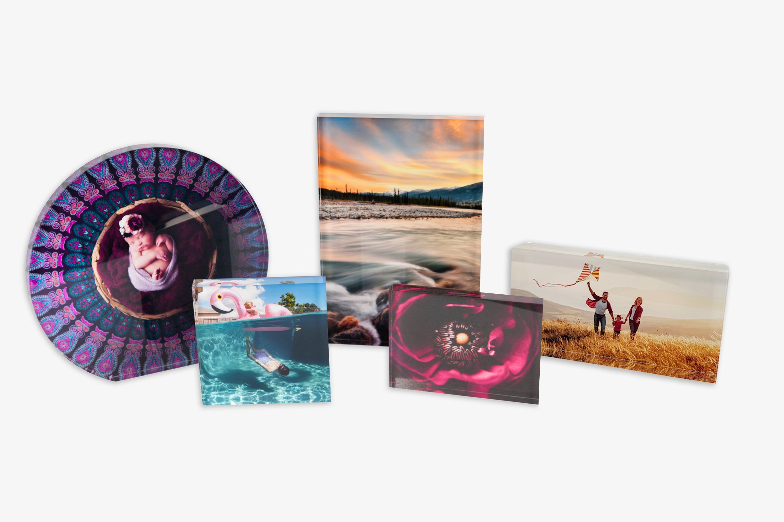 Collection of seven printed photos, including a baby wrapped in a blanket on a decorative plate, a woman floating with a flamingo float in a pool, a sunset over a river with mountains in the background, a family flying a kite in a field, and close-up
