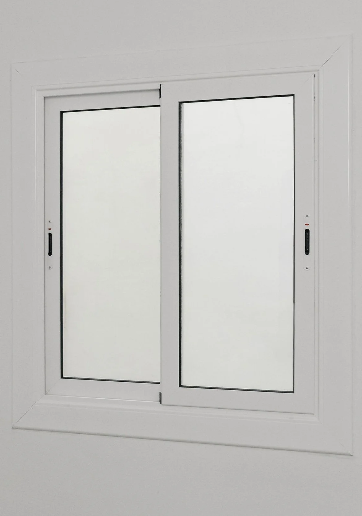 Ventana de vidrio con marco blanco y persianas corredizas en una pared blanca.