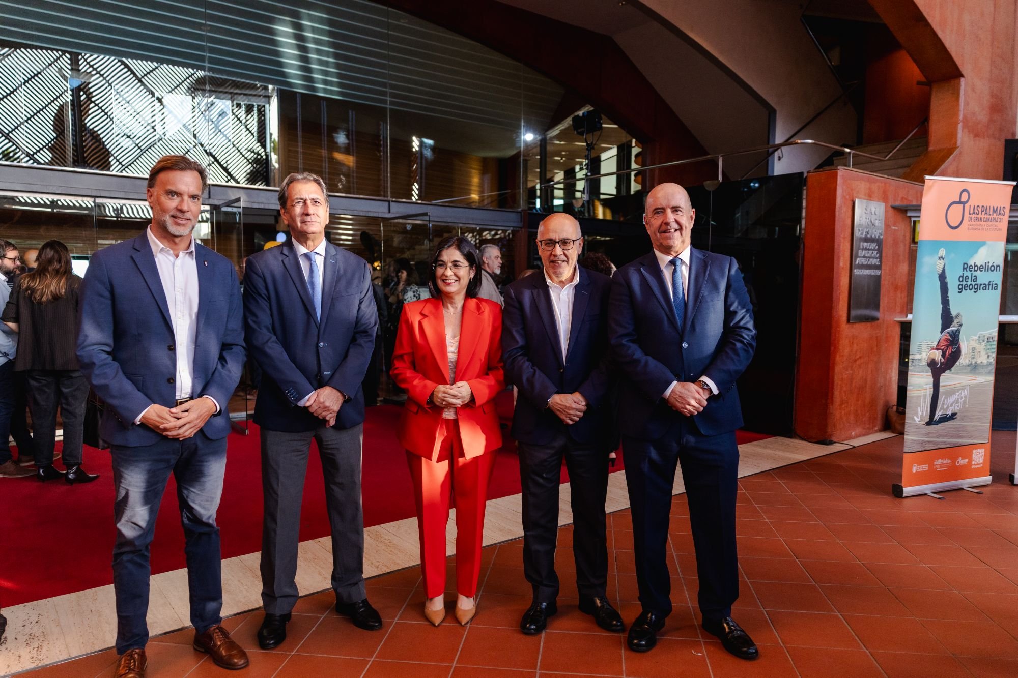 Ciro Gutiérrez, Luis Padrón, Carolina Darias, Antonio Morales y Pedro Ortega posan de pie en el vestíbulo del Auditorio Alfredo Kraus, junto a un cartel de Rebelión de la Geografía