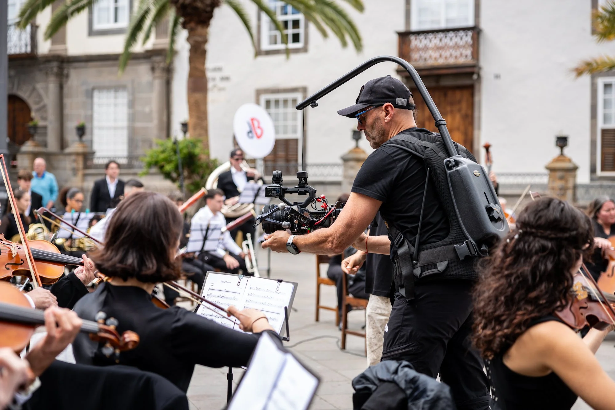 Un cámara graba con un estabilizador a un grupo de violinistas durante la grabación del EP Sinfónico de La Musicleta en la plaza de Santa Ana
