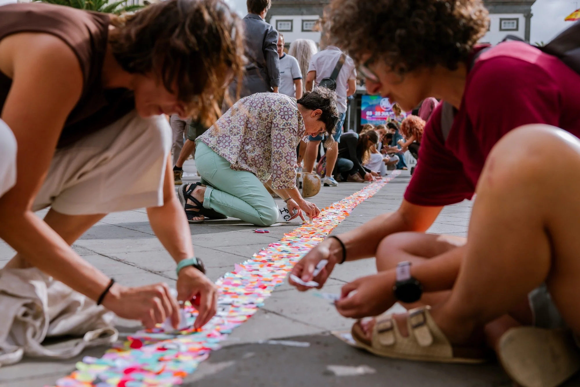 Participantes escribiendo nuevas palabras en el suelo durante la marcha colectiva de Art al Quadrat por el casco histórico