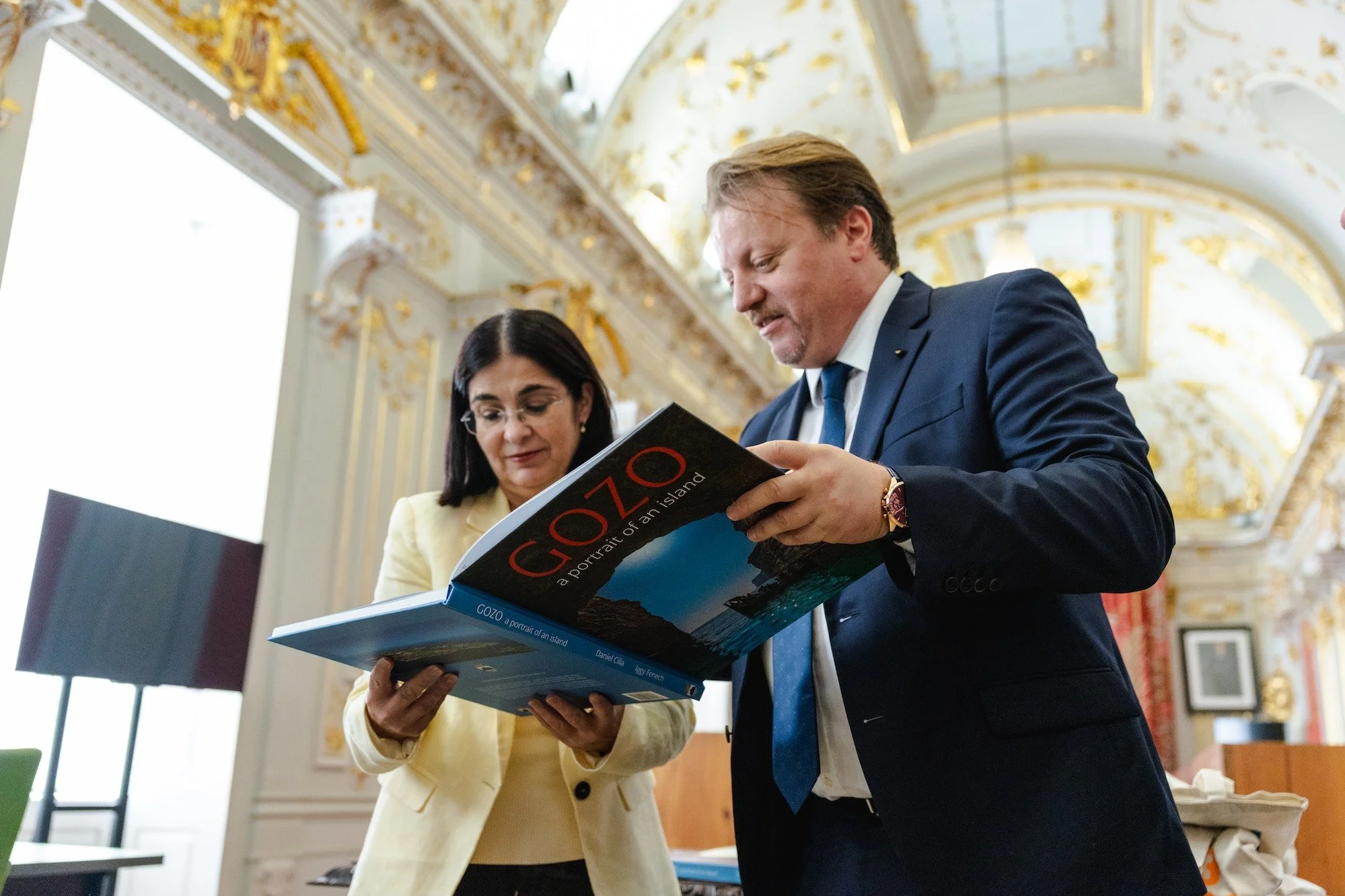 El alcalde de Victoria, Brian Azzopardi, muestra a la alcaldesa Carolina Darias el libro "Gozo: A Portrait of an Island" durante su visita a Las Palmas de Gran Canaria