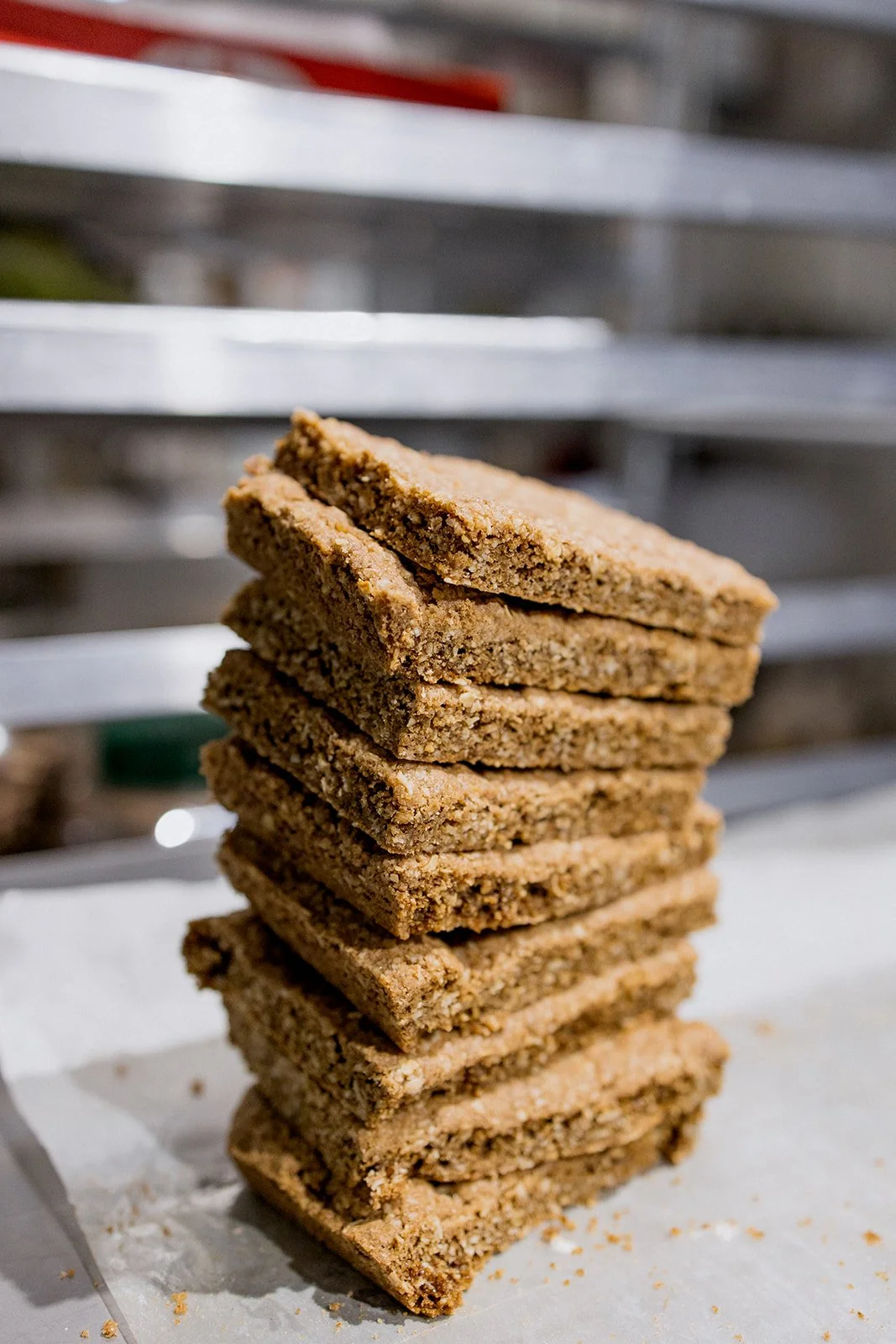 Stack of cookie bars on parchment paper with a blurred metal background.