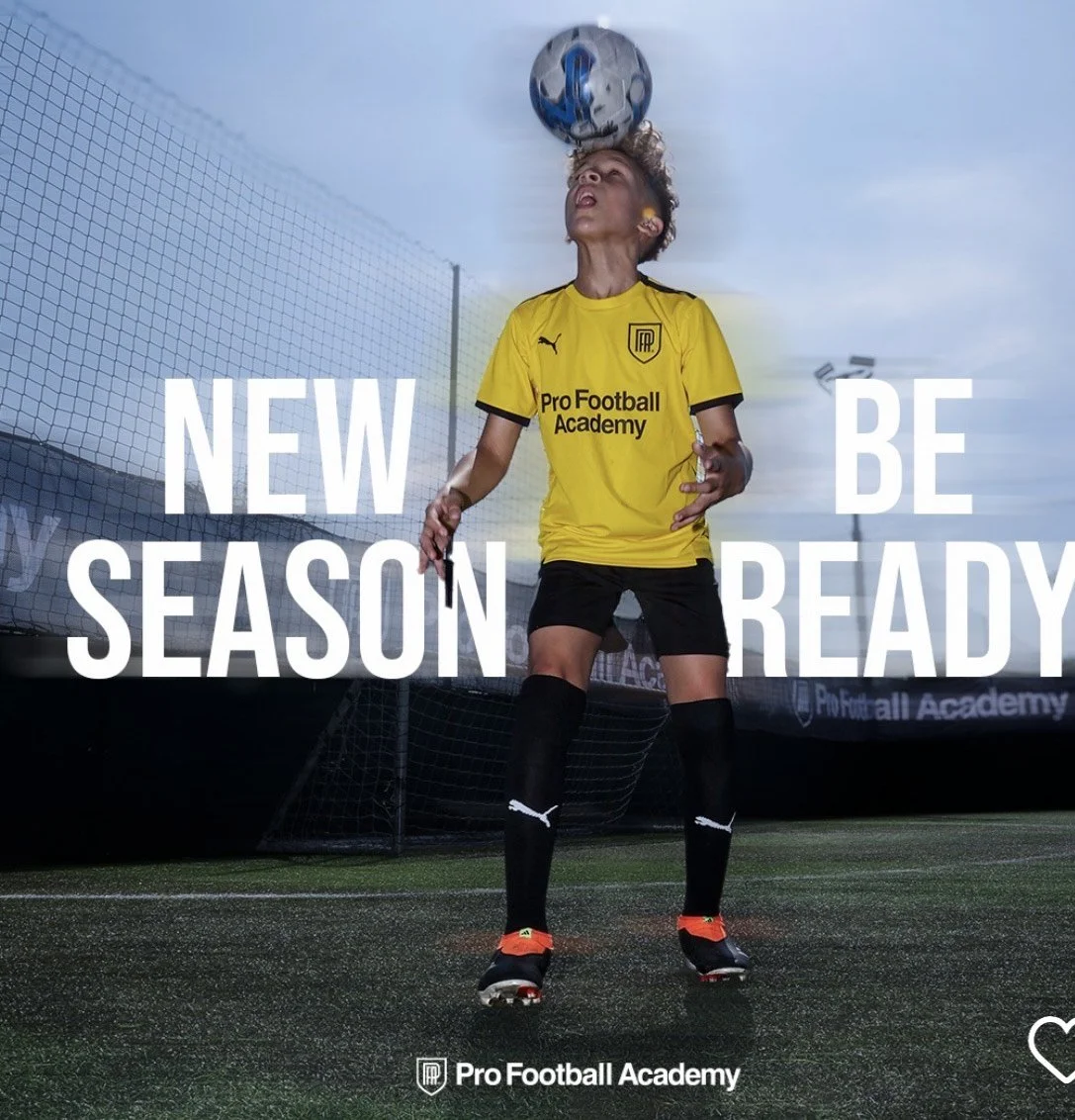 Young soccer player in yellow jersey and black shorts heading a soccer ball on a field, with the text 'New Season Be Ready' and 'Pro Football Academy' visible.