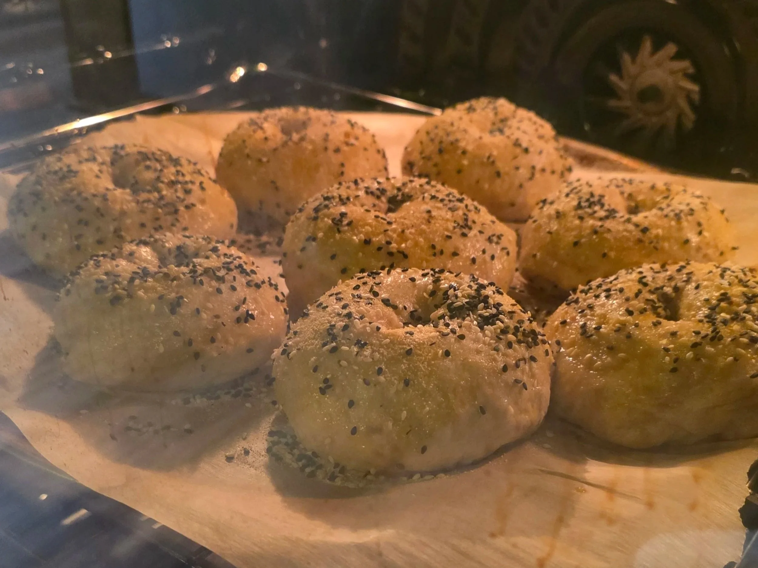 Sourdough discard bagels baking in over on parchment paper