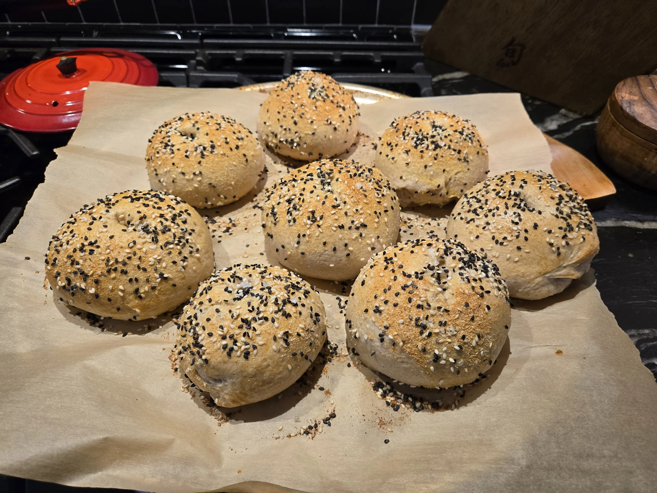 Homemade sourdough discard bagels with sesame and poppy seeds on parchment paper