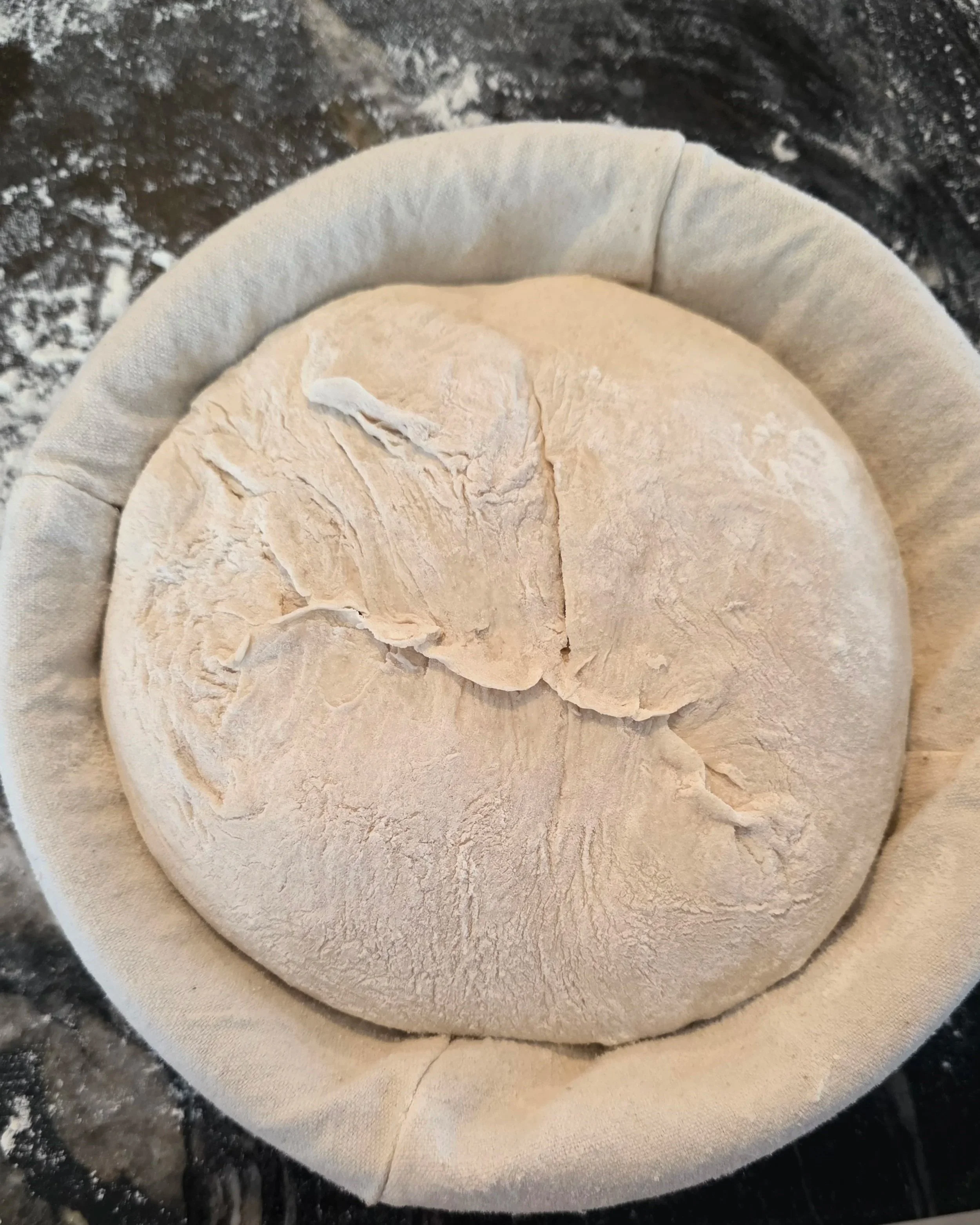 Sourdough dough ball proofing in banneton basket with linen cloth