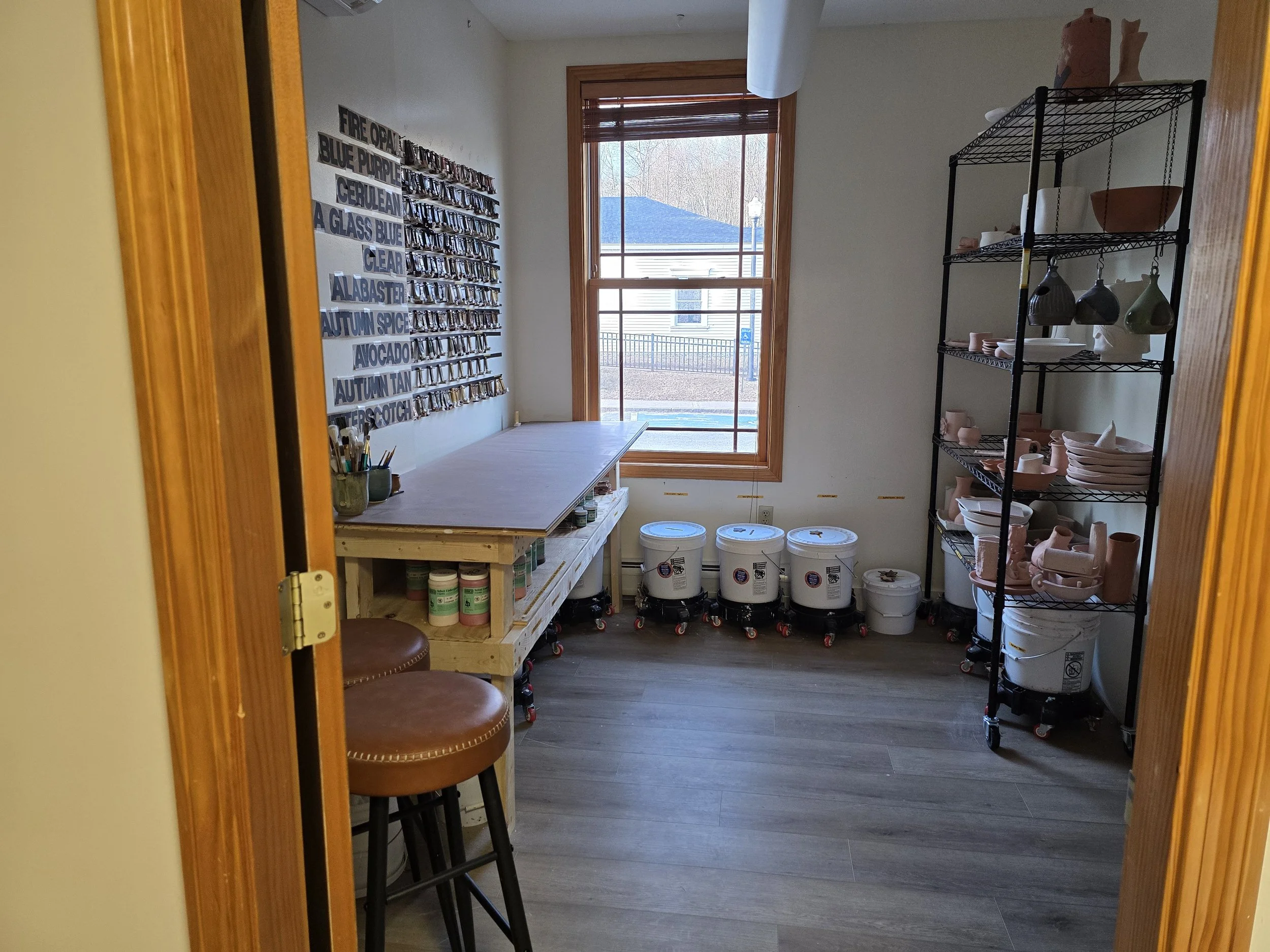 A view into a room full of 5-gallon buckets of glaze for stoneware pottery at a studio in Gorham, NH.