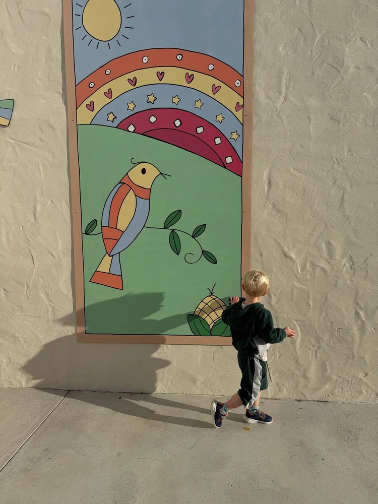 A child walking past the mural on the Center playground