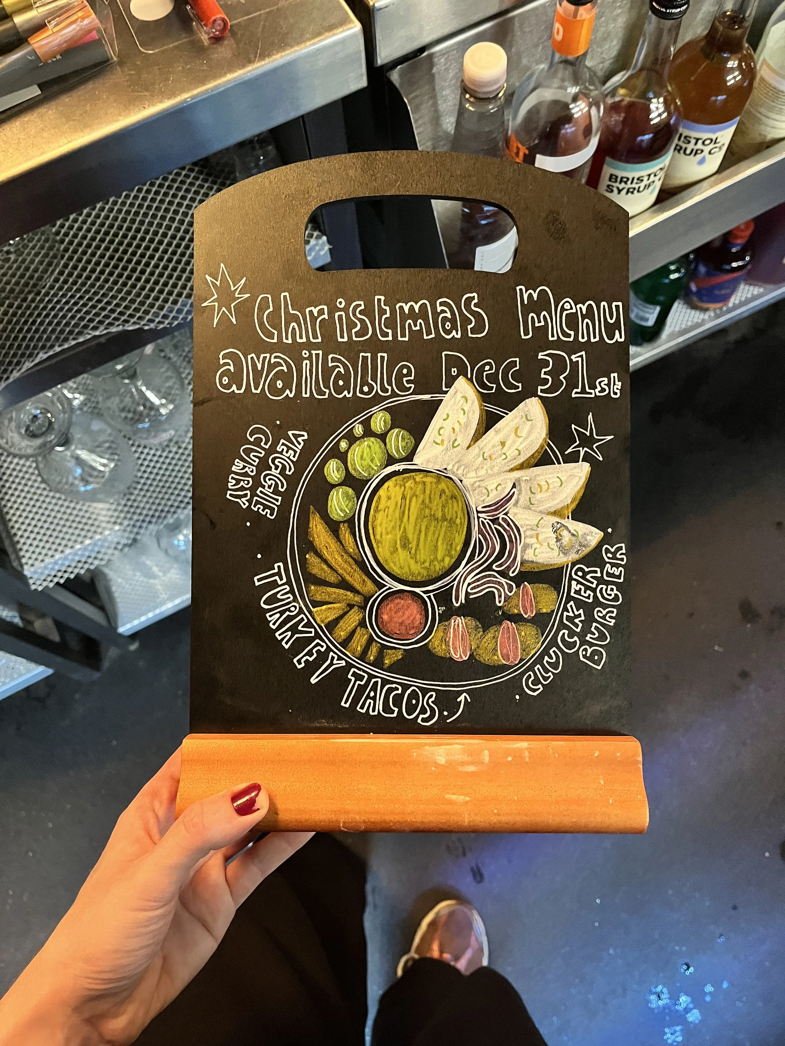 A4 sized Chalkboard promoting 'Christmas Menu + other items available until December 31st'. Hand Drawn text + image using Posca Markers (2025).