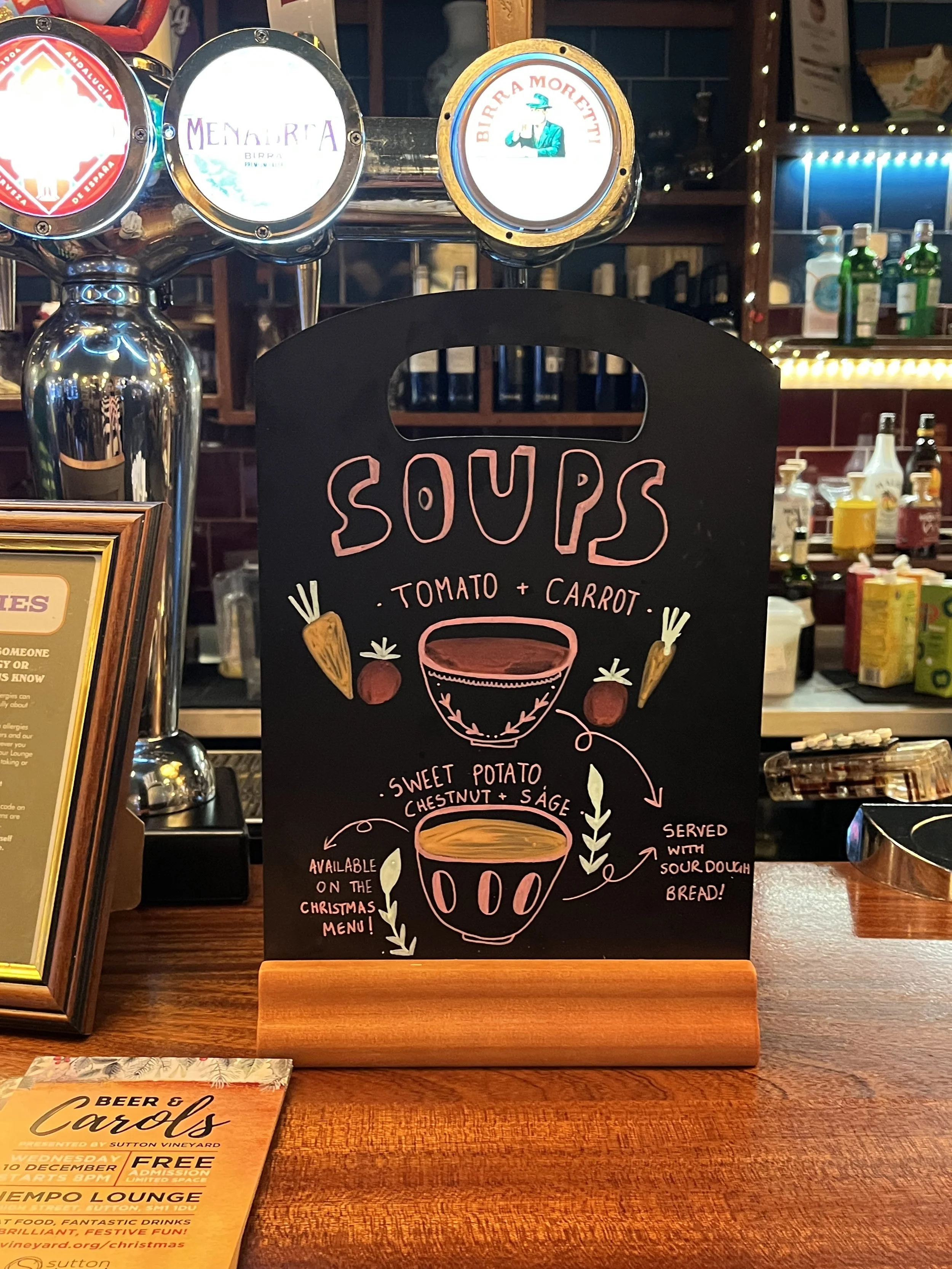 A4 sized Chalkboard promoting 'Soup flavours available'. Hand Drawn text + image using Posca Markers (2025).