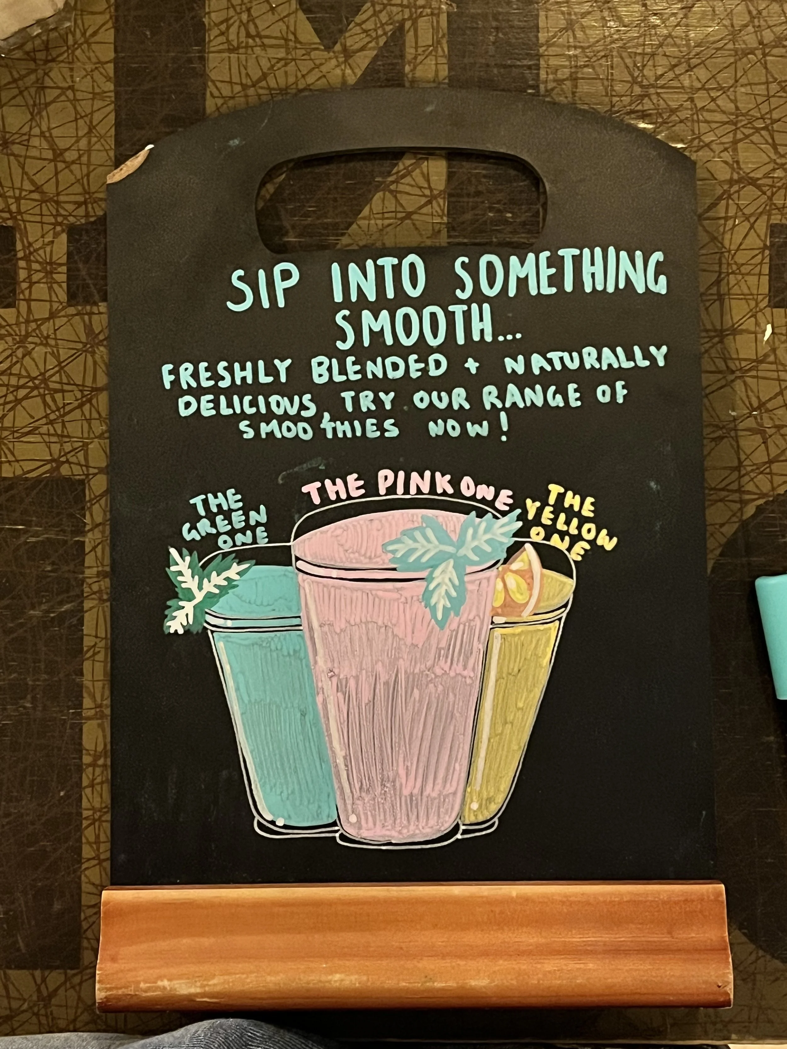 A4 sized Chalkboard promoting 'The Pink, The Green and The Orange One Smoothies'. Hand Drawn text + image using Posca Markers (2025).