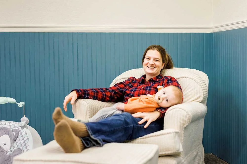 Woman reclining and holding an infant