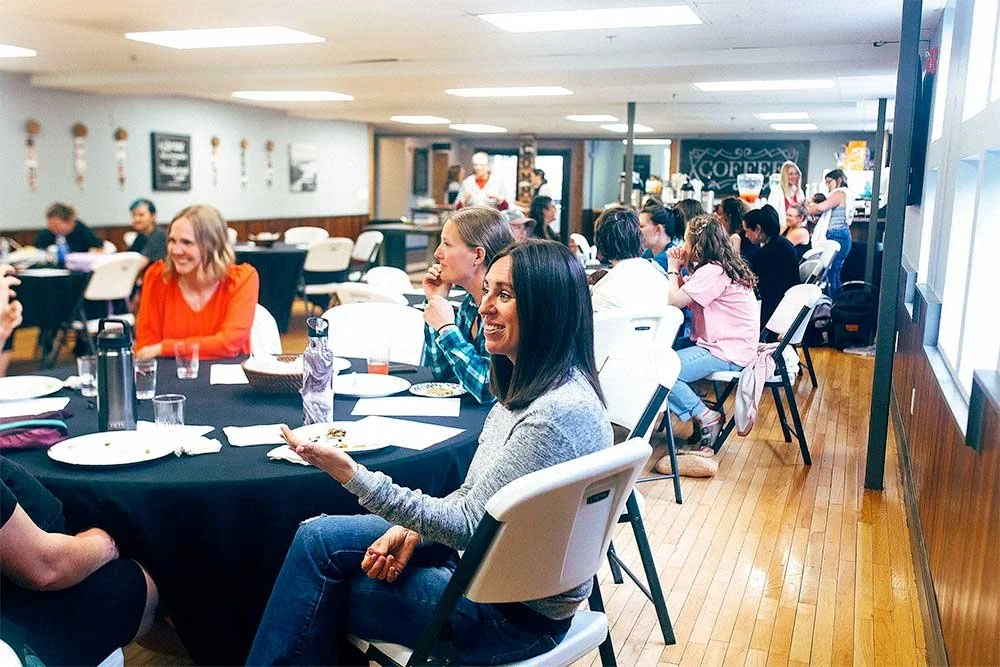 Group of women sitting and chatting at tables