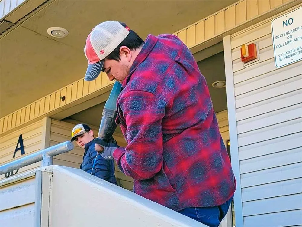Man installing a handrail with a power drill