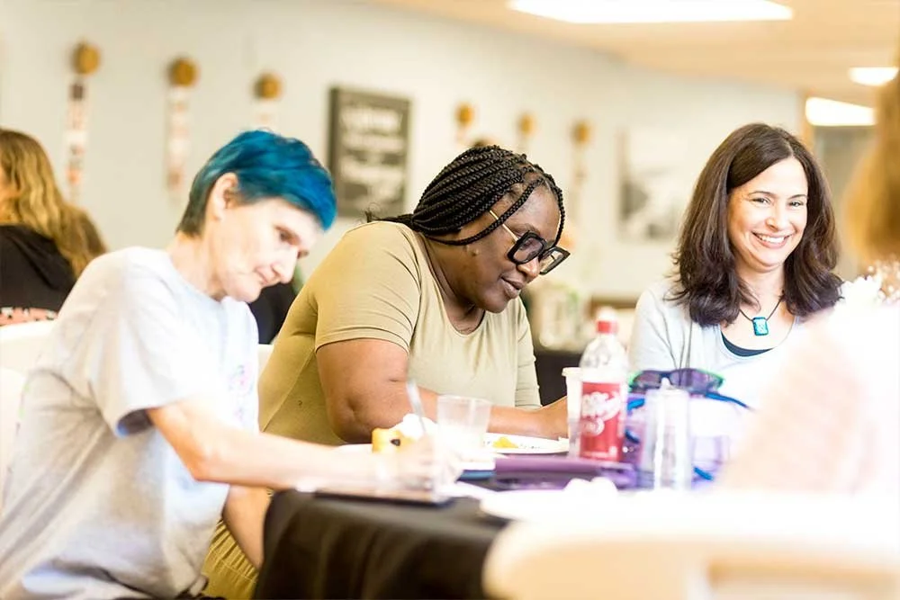 Three women sitting and taking notes at a table