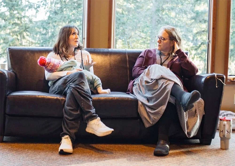 Two women sitting on a sofa engaged in conversation