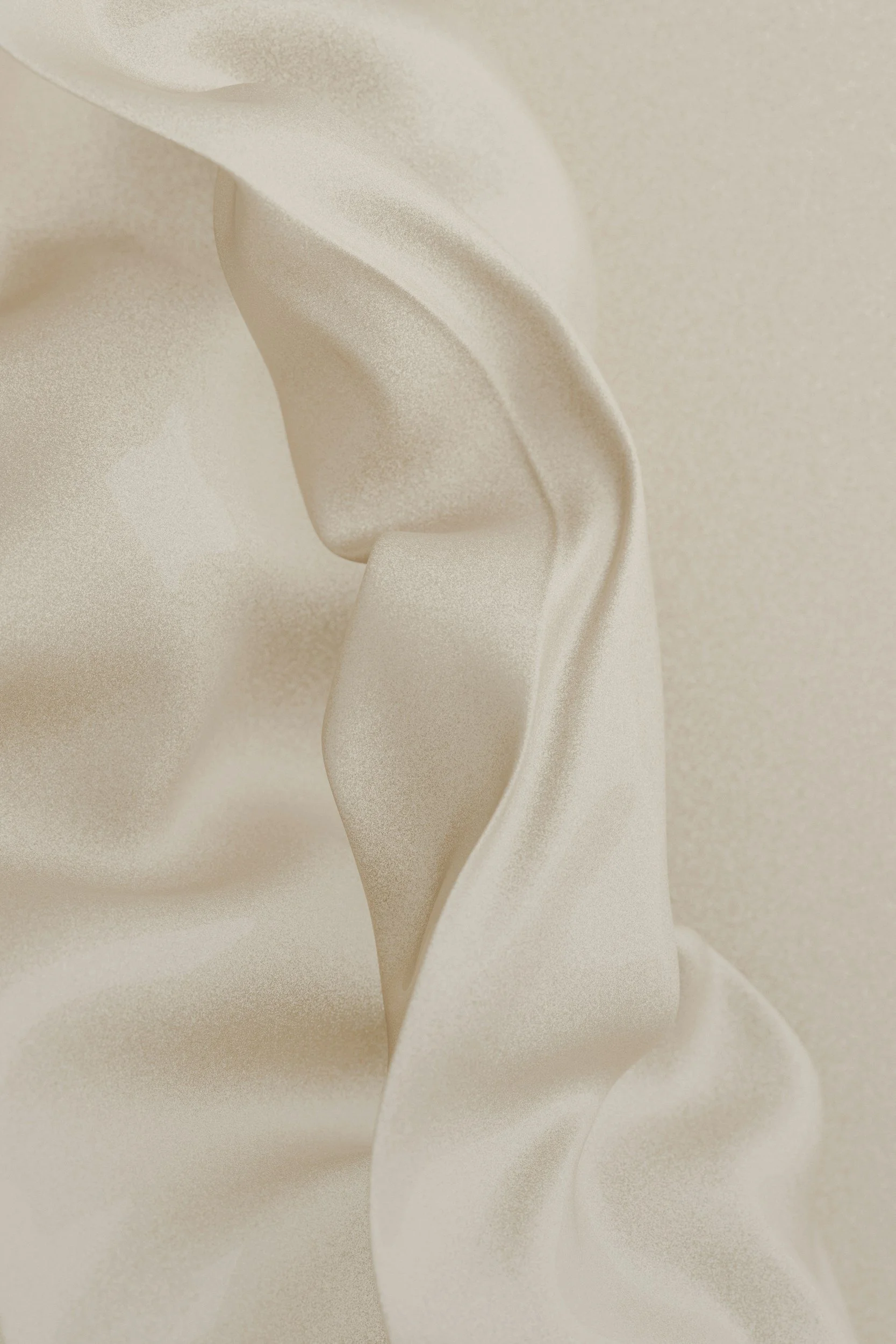 Close-up of beige satin fabric with soft folds and smooth texture.