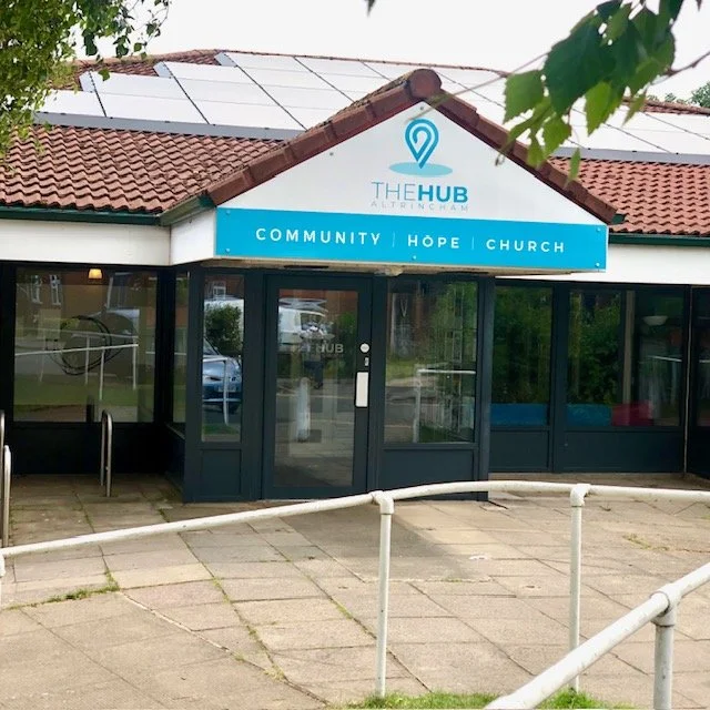 The HUB community center with a sign reading 'COMMUNITY | HOPE | CHURCH'.