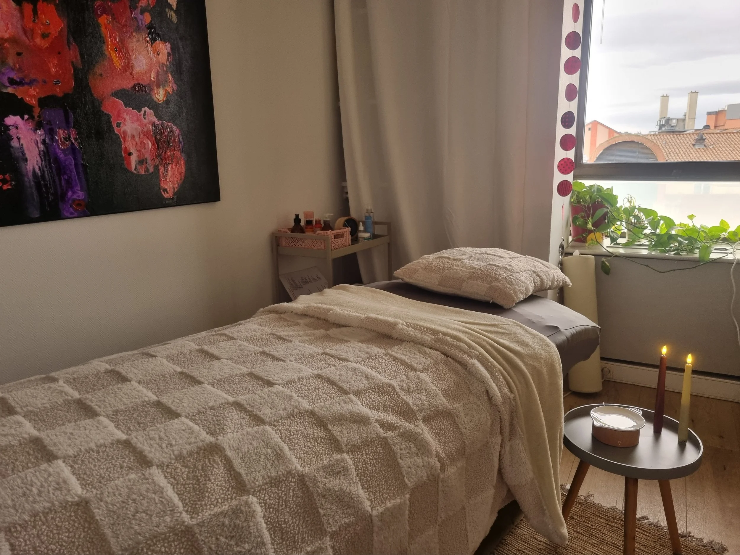 Table de massage douillette chauffée en hiver dans une ambiance cosy, à la lumière de bougies LED réalistes.