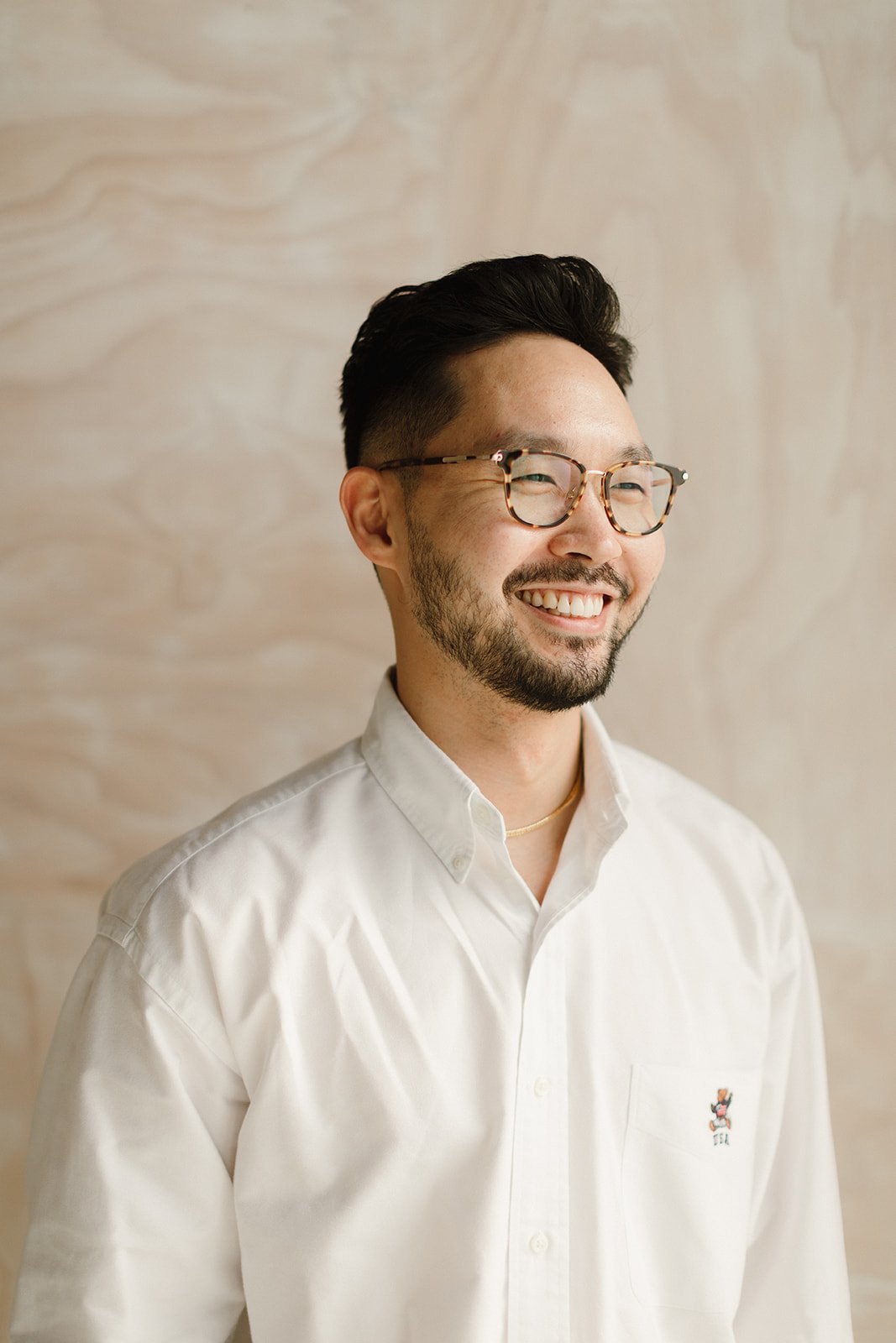 Joon Lee, LICSW, smiling warmly in sunlit space — an online therapist bringing authenticity and real connection.