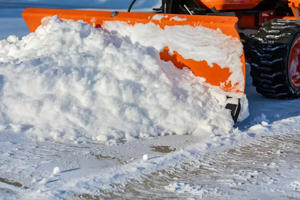 orange snow plow plowing sidewalks in Riverton Utah