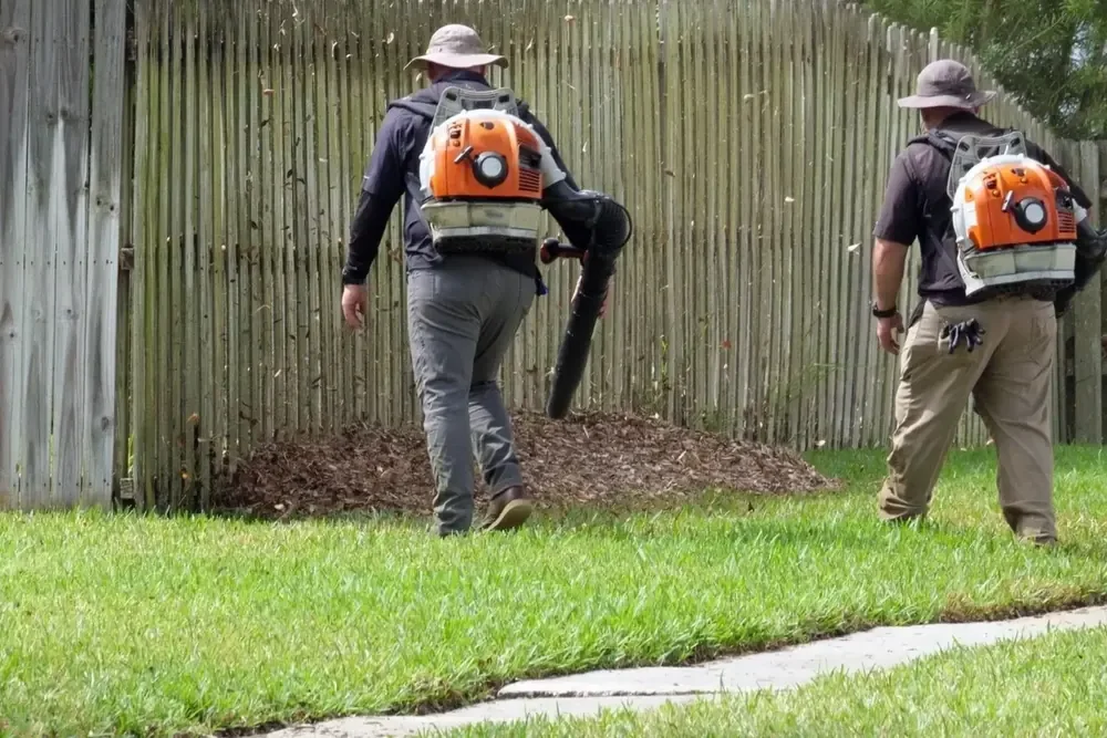 Crew using leaf blowers along a fence in Alpine, Utah