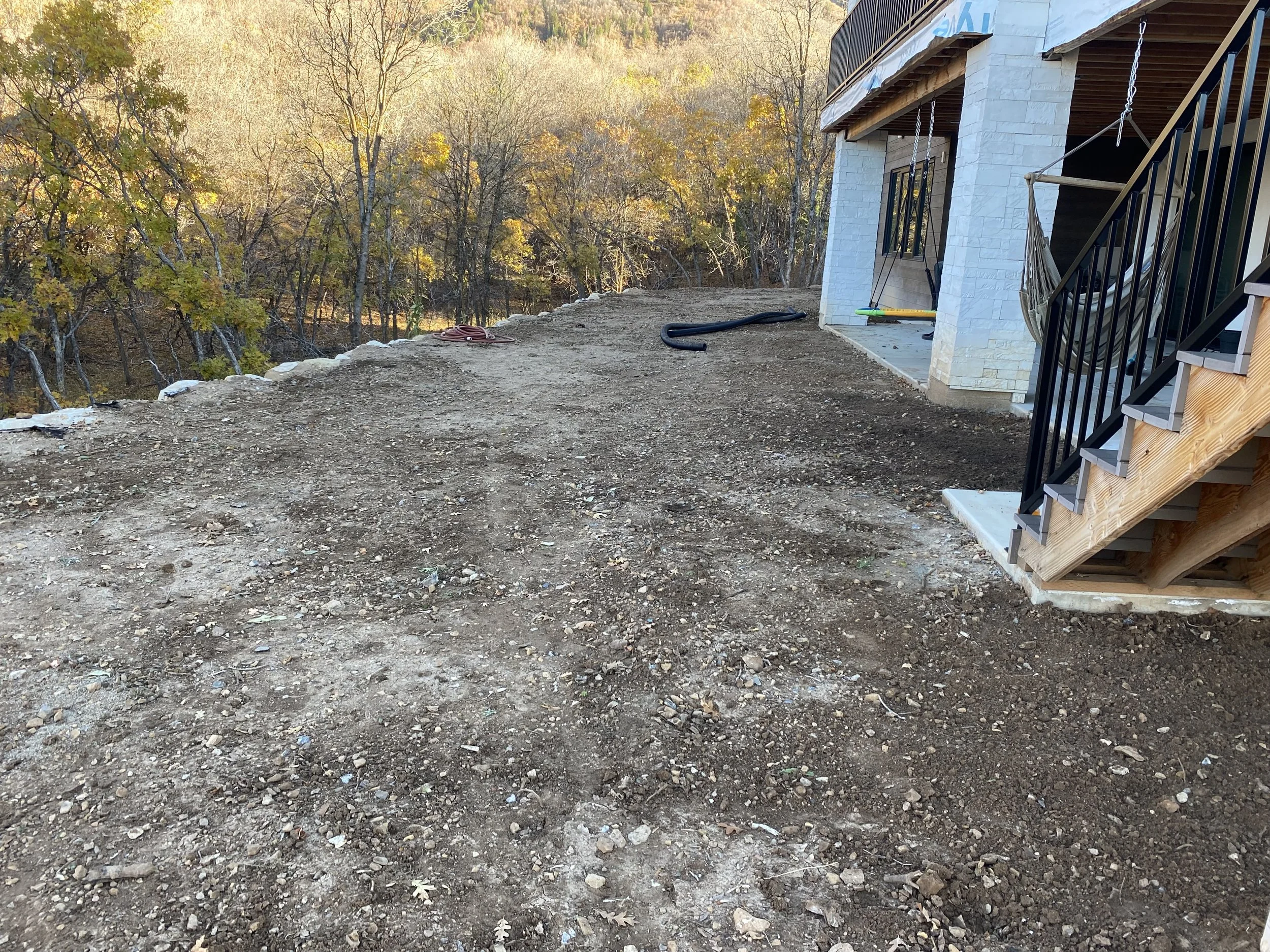 Before view of uneven, overgrown backyard in Woodland Hills Utah prior to full transformation