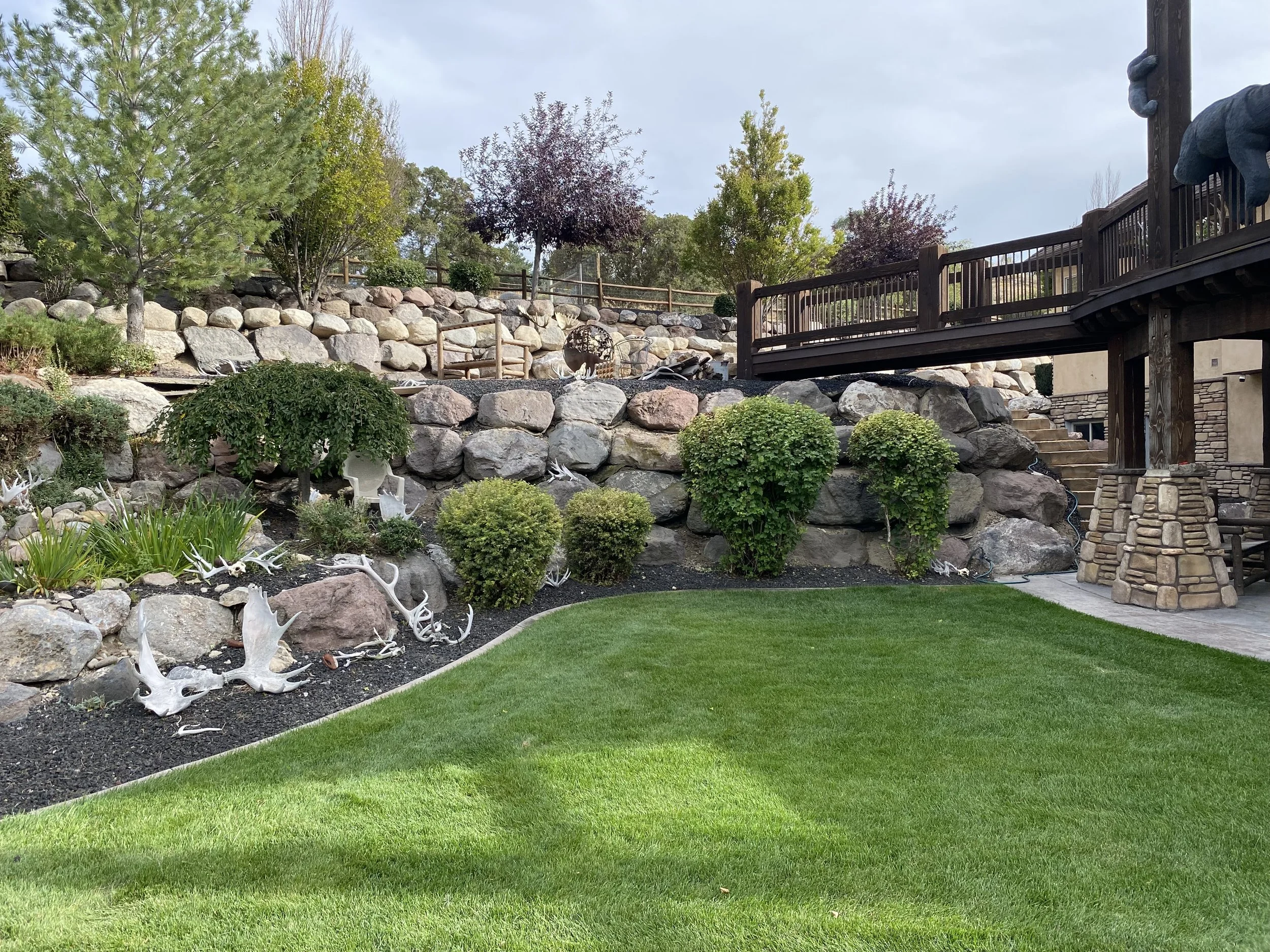 backyard in Lehi Utah with rock wall and sheds