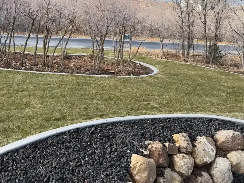 Stone-edged flower bed and fresh lawn in a Utah front yard