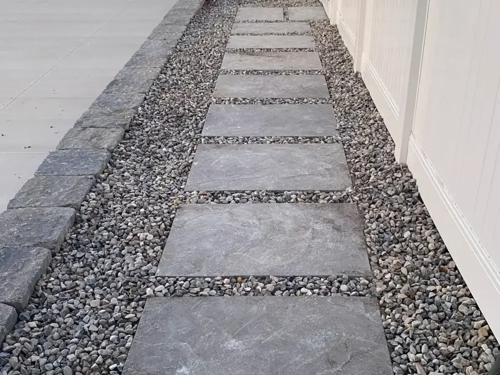 Stepping-stone walkway with gravel beside a white fence in Utah