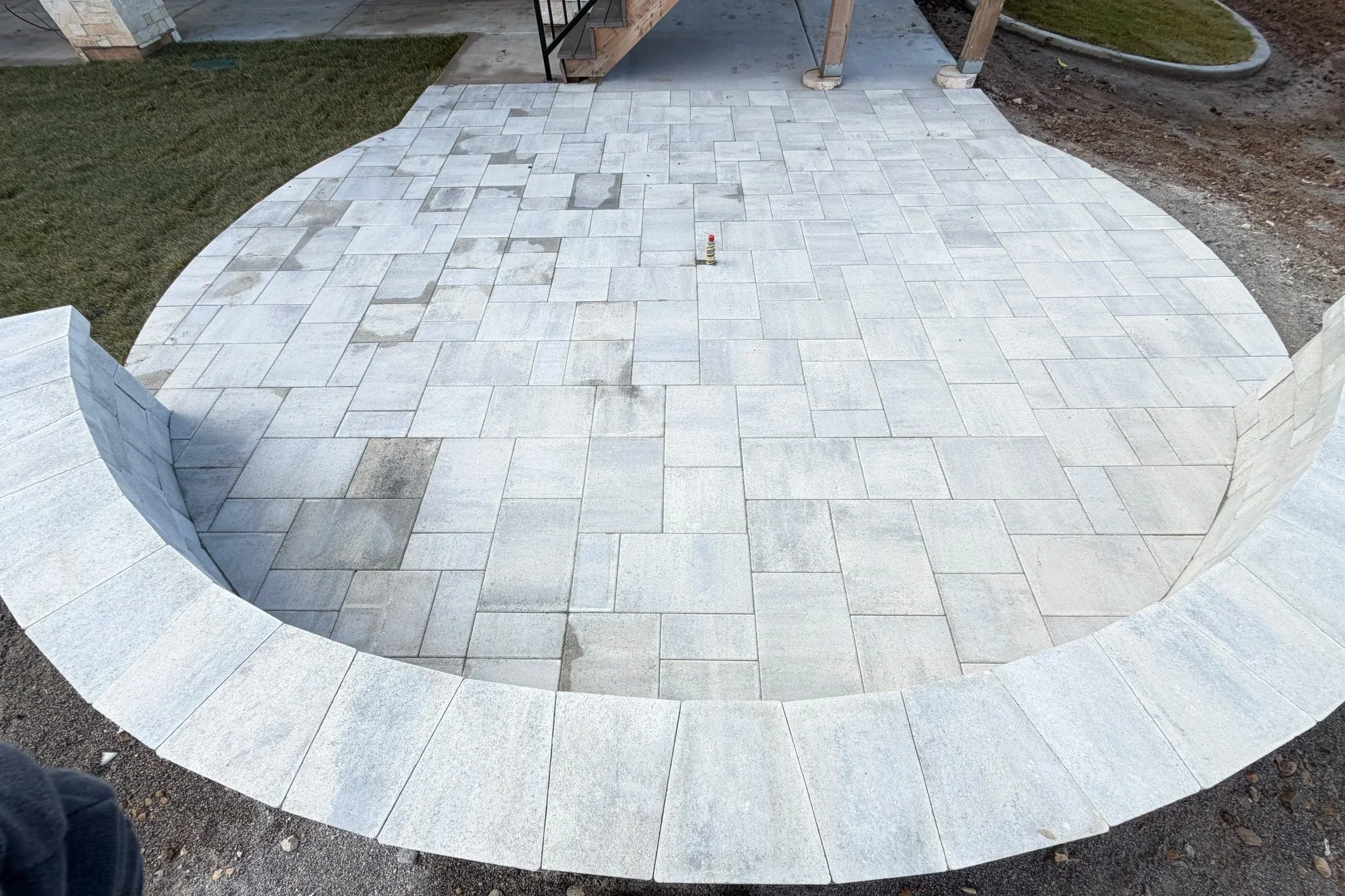 Finished Woodland Hills Utah backyard oasis with custom fire pit, inground trampoline, concrete hardscaping and irrigated grass