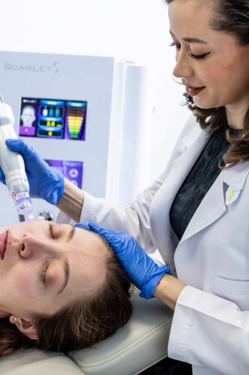 Una médica realizando un procedimiento de rejuvenecimiento facial a una paciente en una clínica médica.