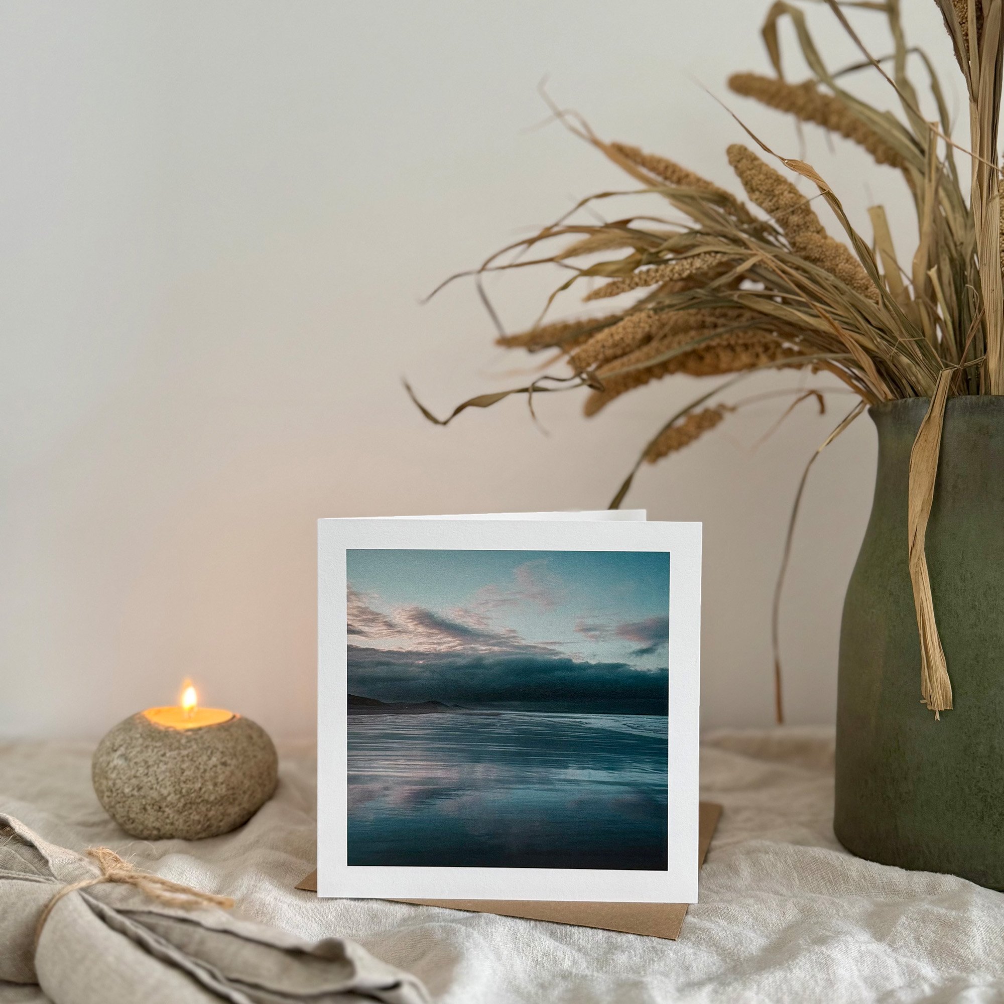 Nature's Mirror greeting card styled with a stone candle and natural décor on a soft linen surface.