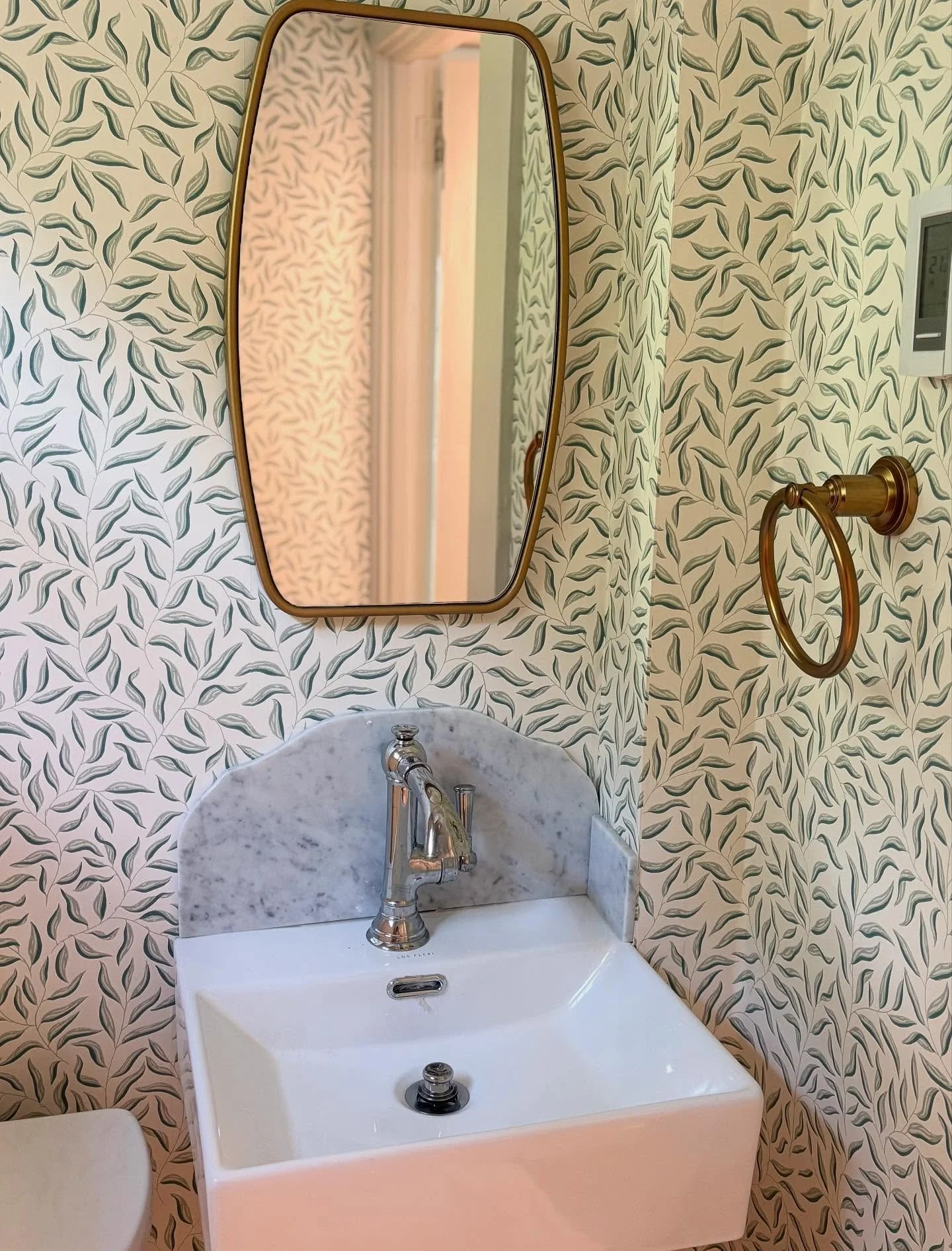 After a complete powder room refresh, the client was worried about her kids splashing water on her brand new wallpaper. I sourced a company able to mill a very thin piece of marble to fit behind her brand new fixture and now she doesn&rsquo;t have to