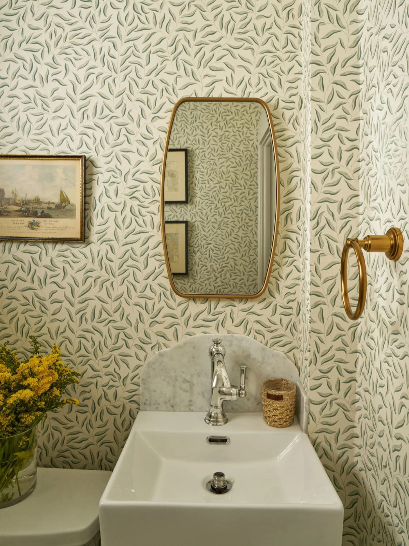 One of the biggest challenges in this powder room was the size. With such a small footprint, a floating vanity was the only option to keep the space feeling open and functional.
To give the room personality, we leaned into a botanical wallpaper that 