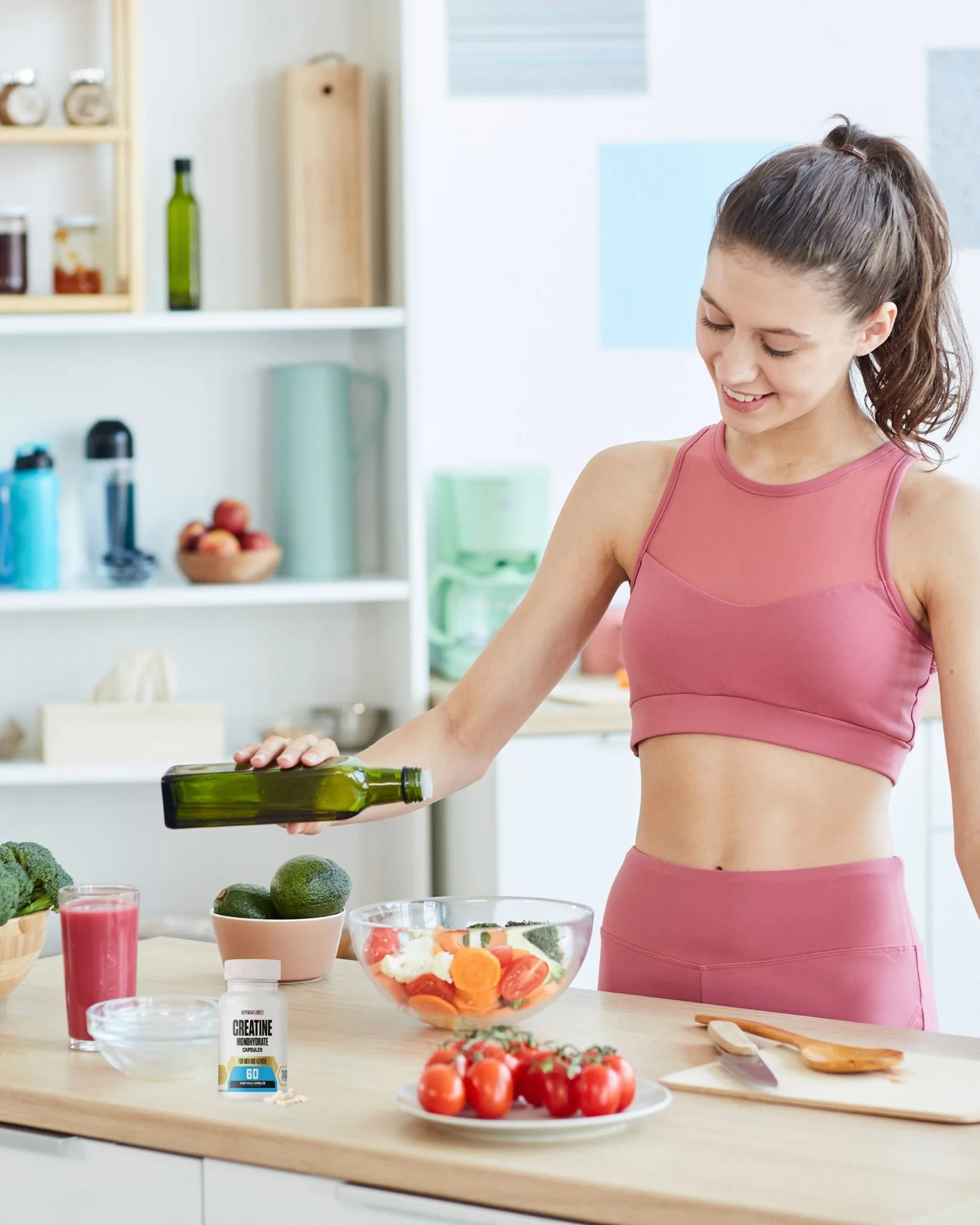 A woman in workout clothes preparing a salad in a bright kitchen.