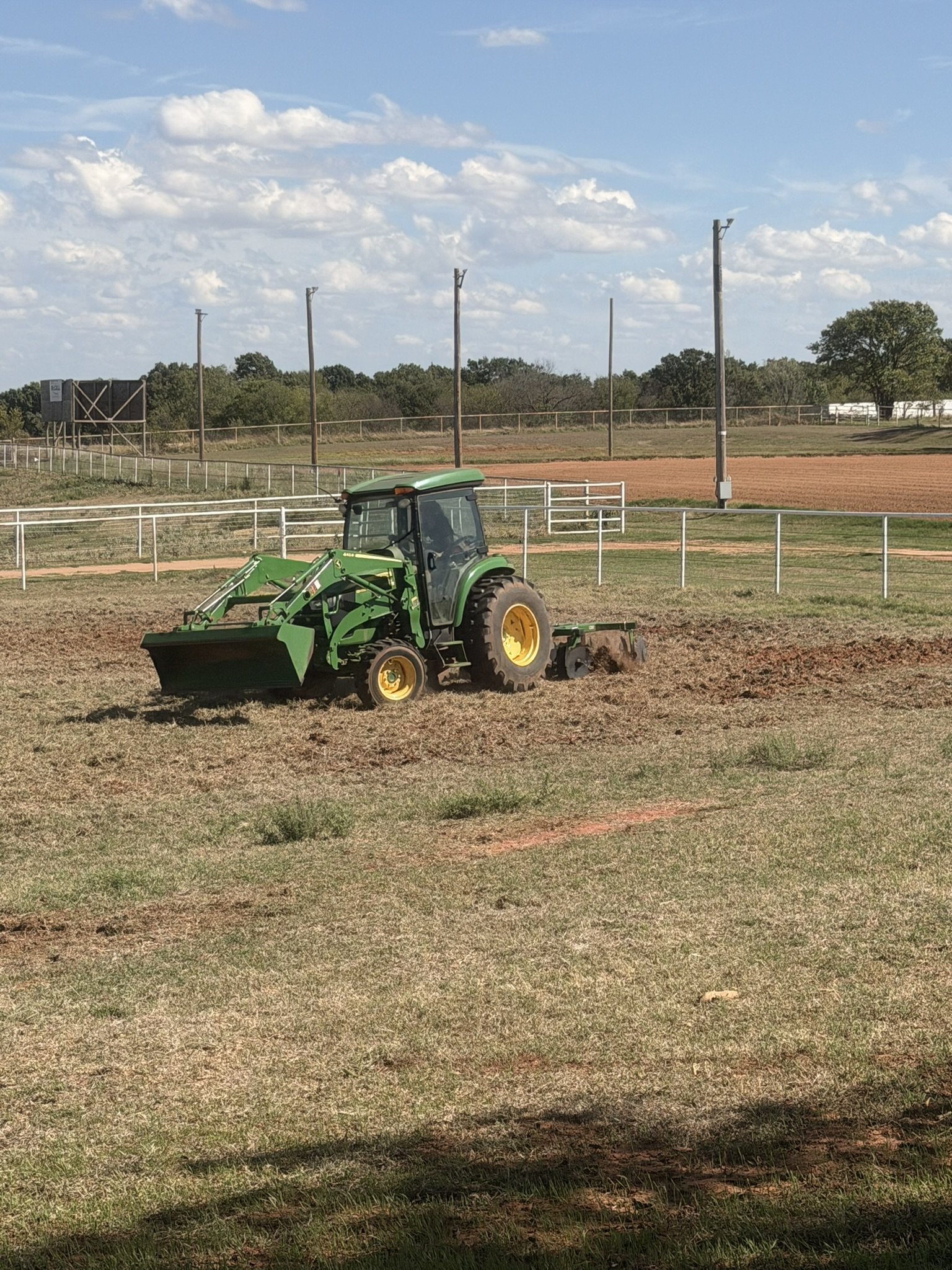 green tractor using a disc harrow
