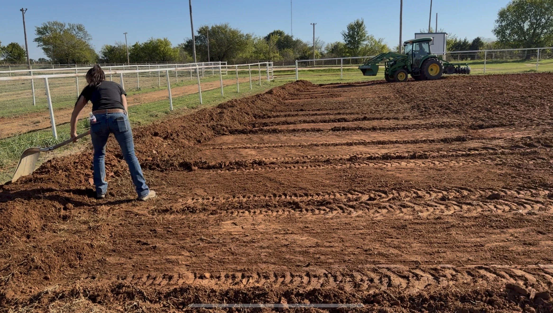 woman using a shovel to shape dirt in a field
