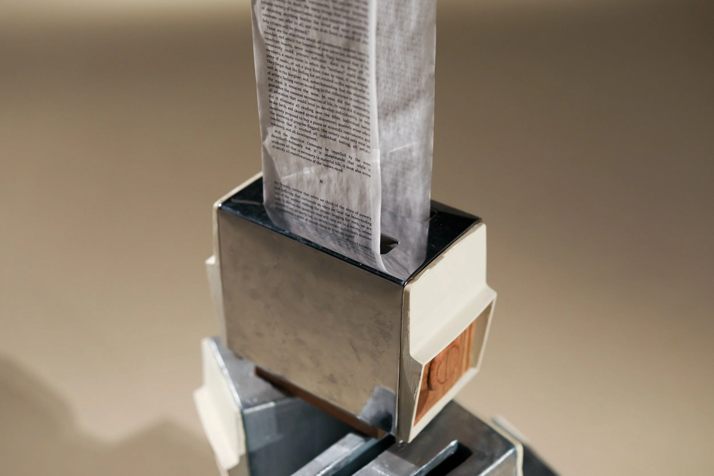 Detail: Becky Sellinger, La Conquête du pain, 2026, plaster, paint, mid century toaster, paper, faux wood drawer liner,  motor 

photo credit: Theo Cote