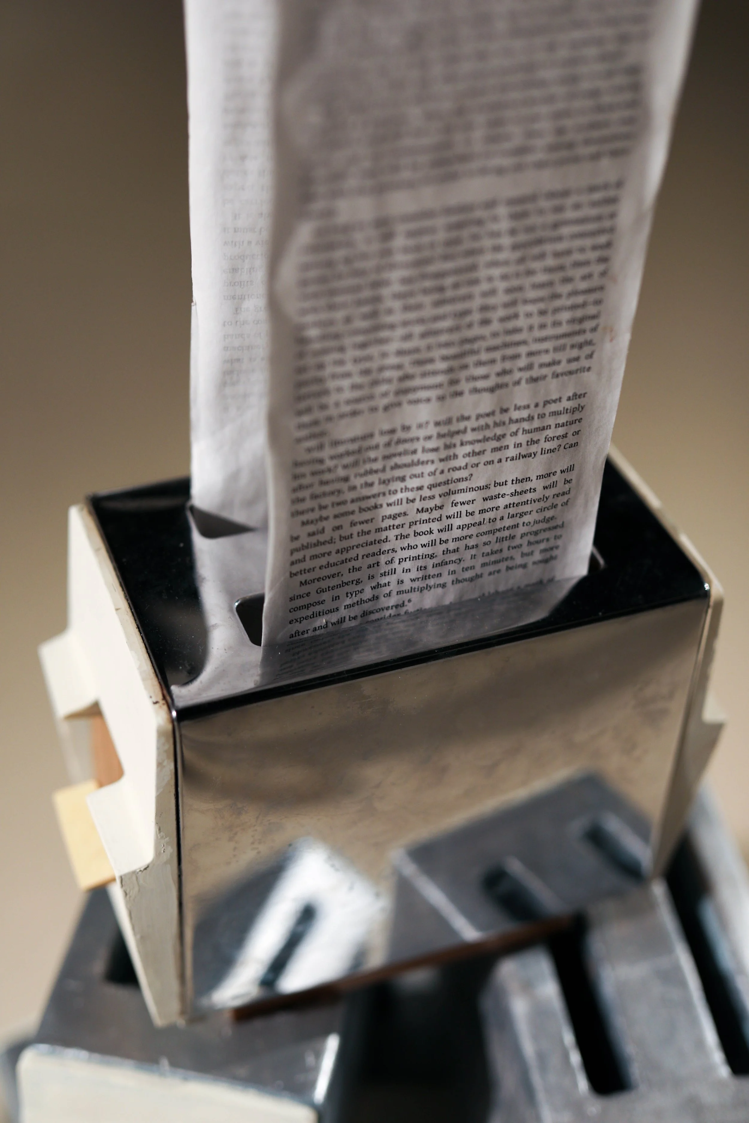 Detail: Becky Sellinger, La Conquête du pain, 2026, plaster, paint, mid century toaster, paper, faux wood drawer liner,  motor 

photo credit: Theo Cote