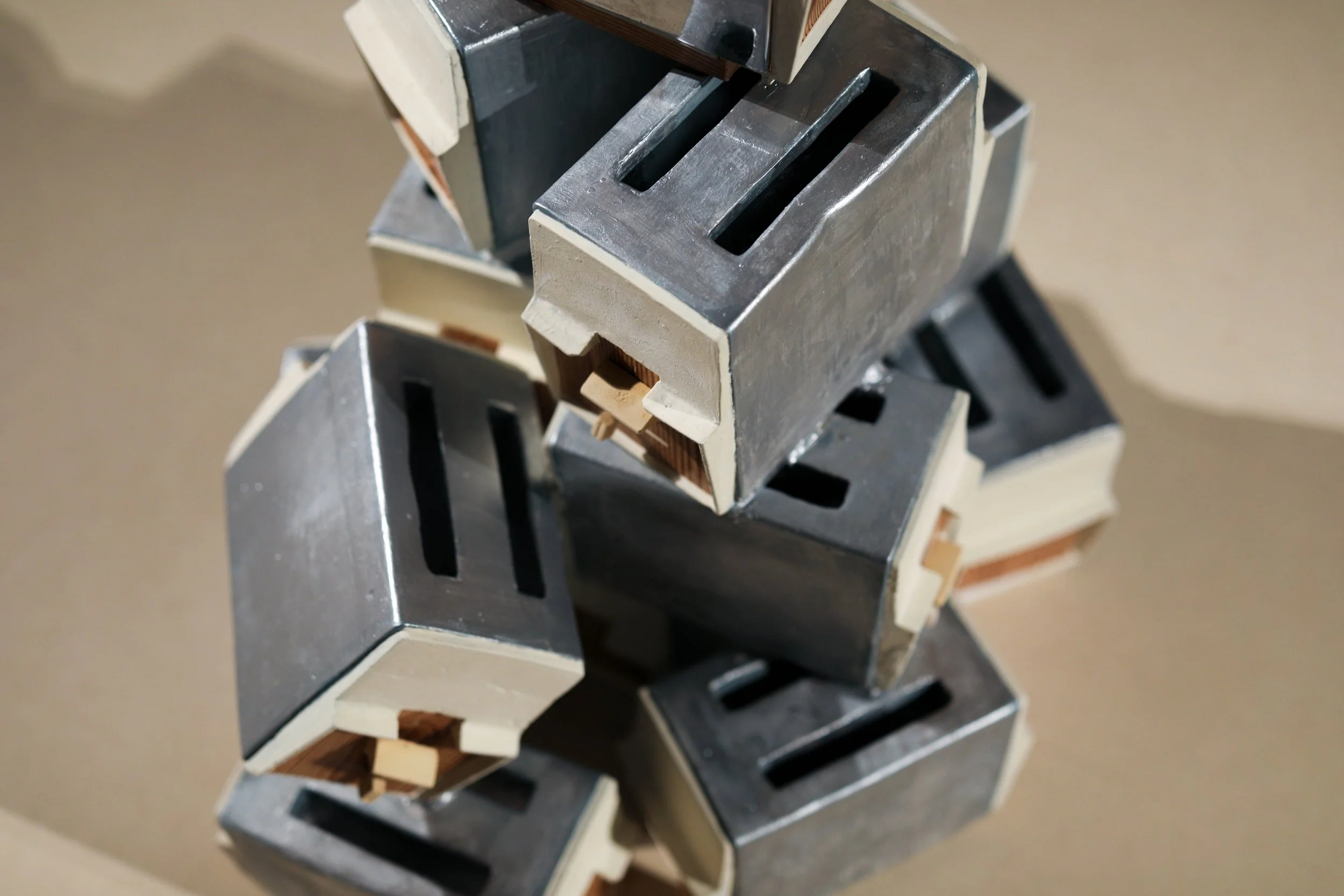 Detail: Becky Sellinger, La Conquête du pain, 2026, plaster, paint, mid century toaster, paper, faux wood drawer liner,  motor 

photo credit: Theo Cote