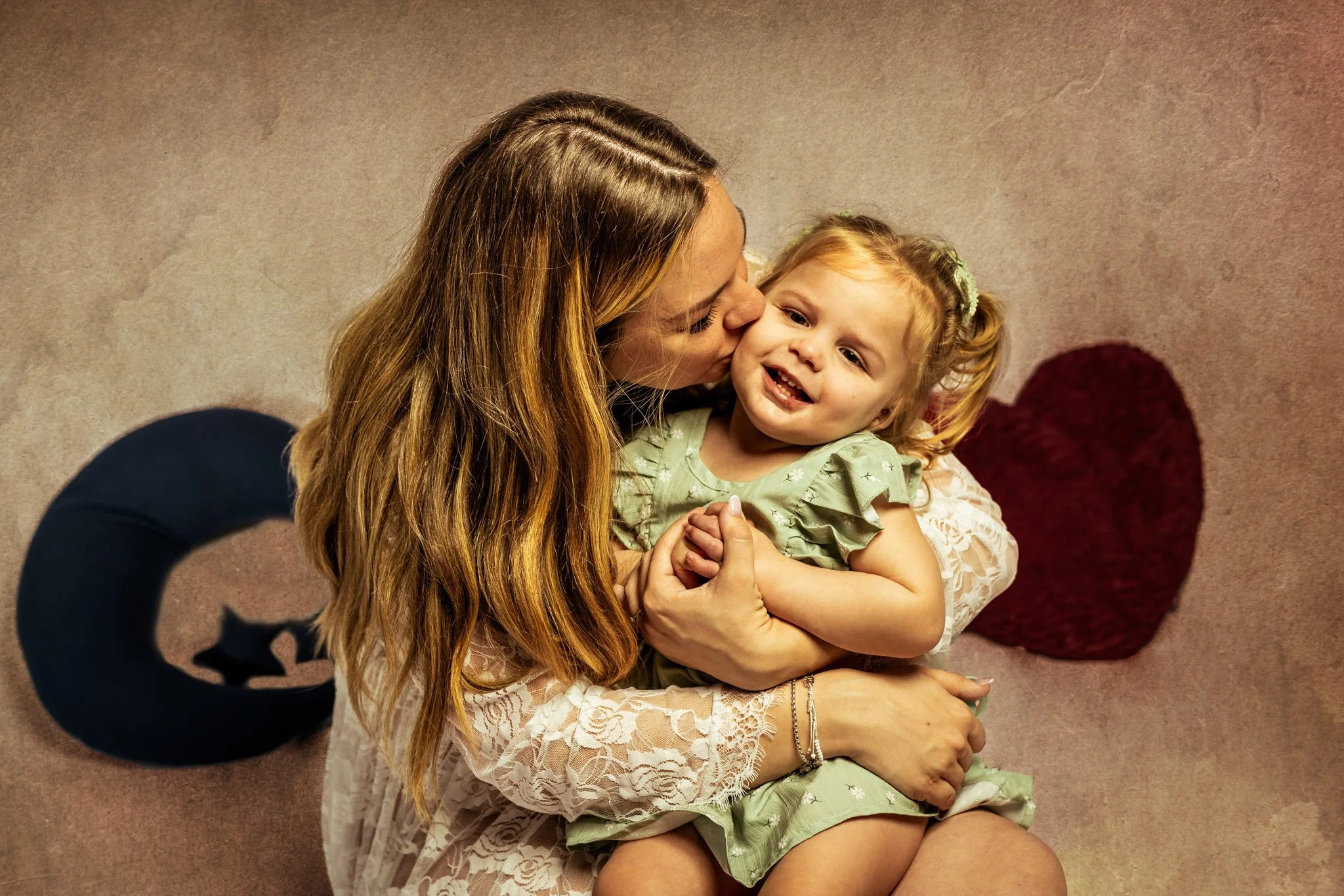 Photo de famille mère et sa fille de 2 ans bisou sur la joue