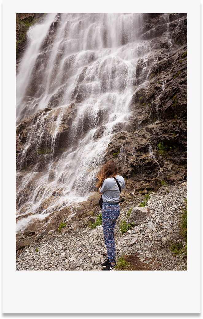Photo style polaroid photographe devant une cascade