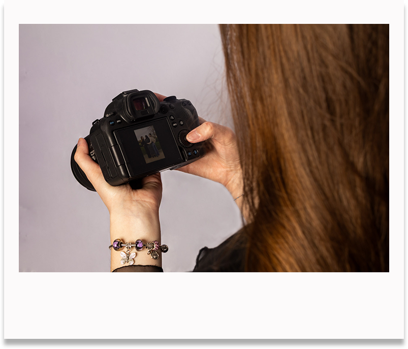 Photo style polaroid photographe qui regarde l'écran de son appareil photo