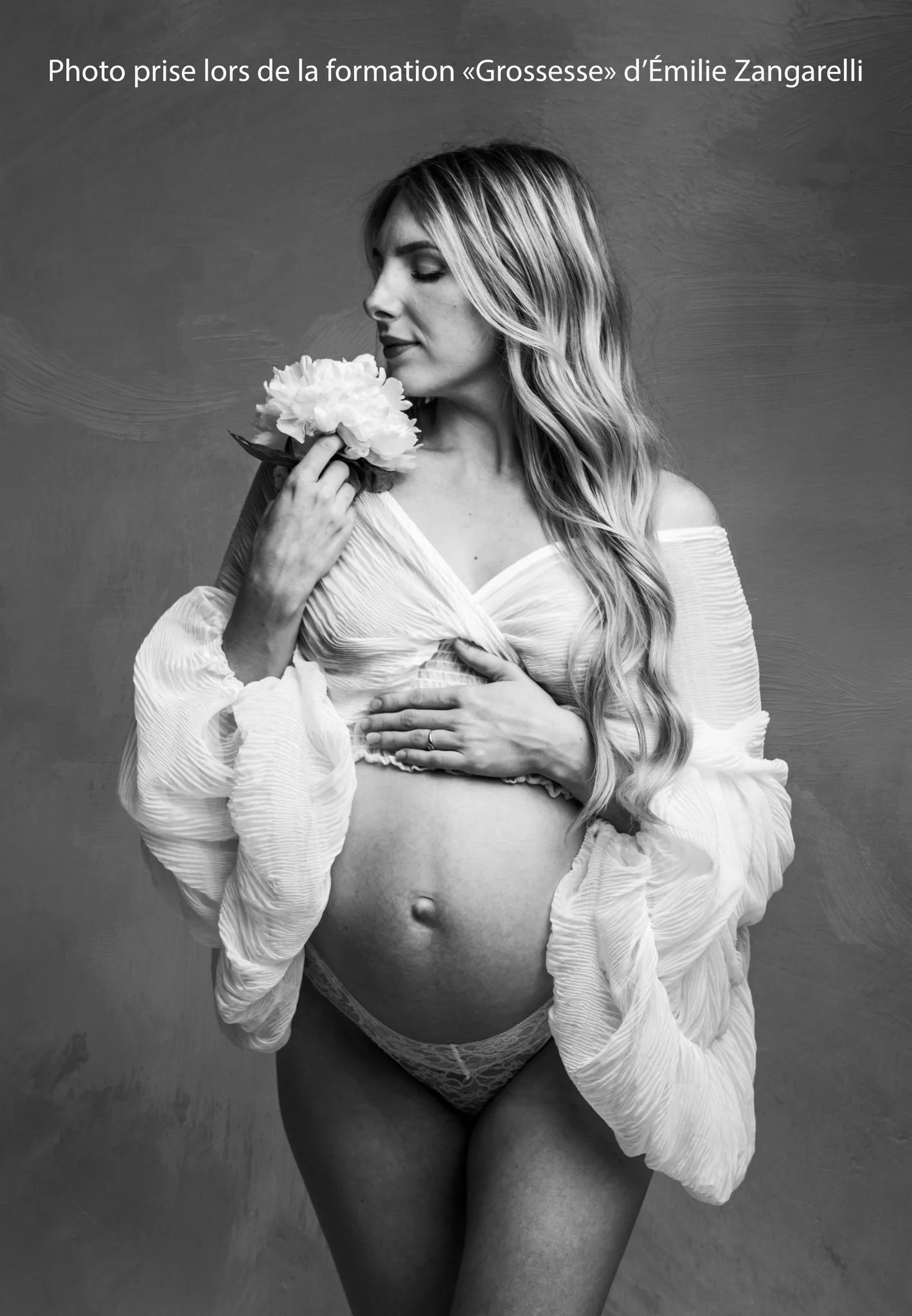 Photo en N&B femme enceinte chemise blanc manches bouffantes et fleurs