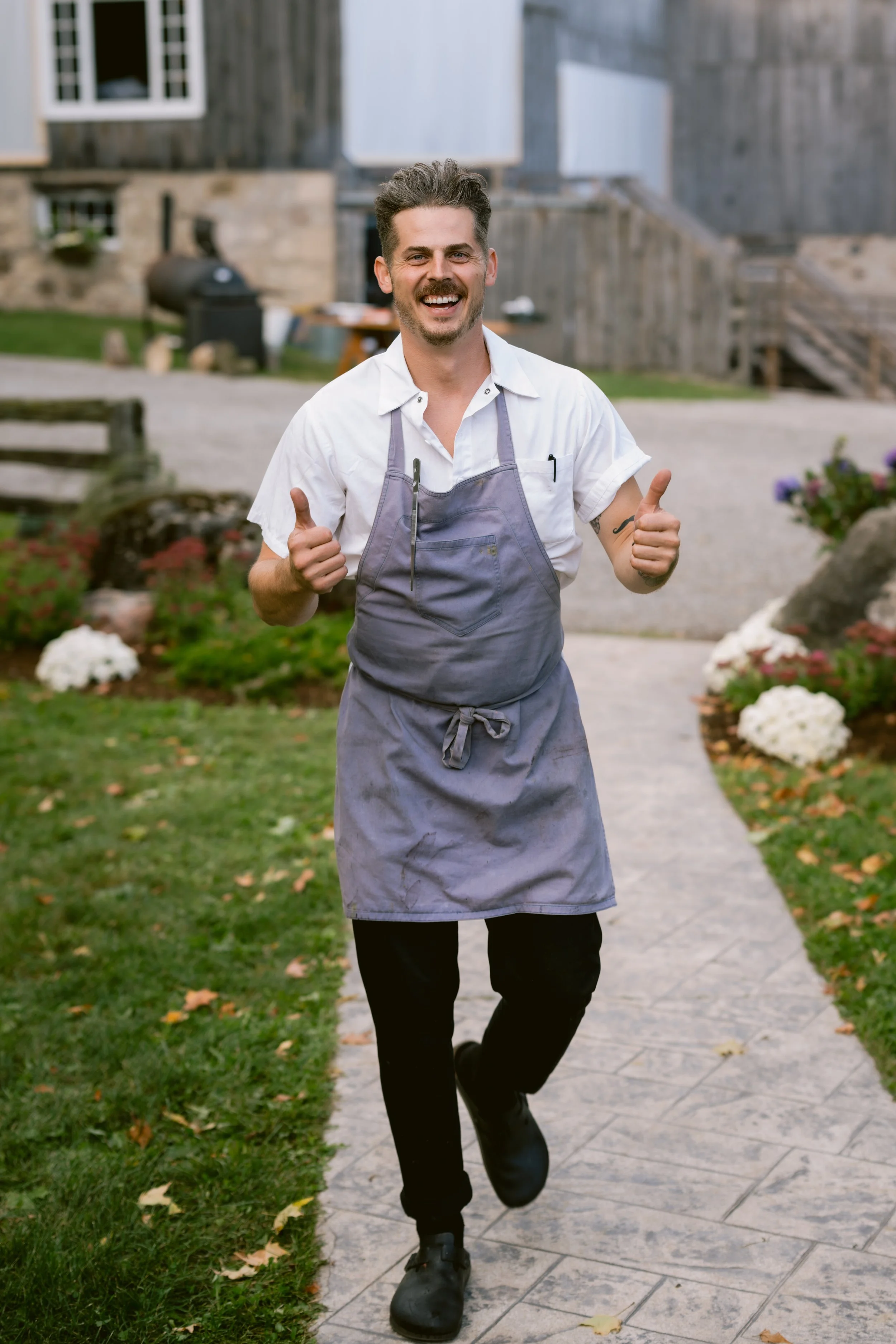 David, Head Chef and owner, gives the thumbs up to a camera man at a farm wedding